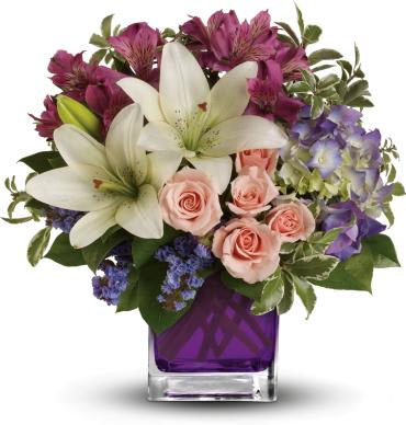 Garden Romance - Va-va-bloom! This stunning arrangement of purple hydrangea, light pink spray roses and white asiatic lilies is perfectly presented in our violet cube.  Purple hydrangea, light pink spray roses, white asiatic lilies, dark pink alstroemeria and lavender sinuata statice are accented with assorted greens. 