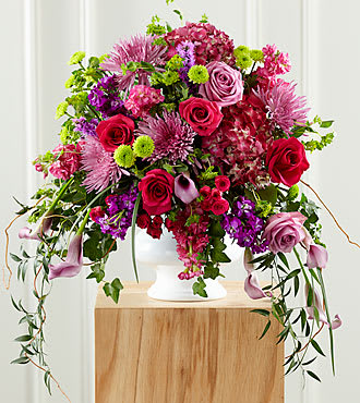 Our Love Eternal Arrangement - When you are looking for an outstanding, yet appropriate expression of sympathy at a wake or funeral, this colorful mixed flower bouquet makes an exquisite choice. This vibrant purple and pink arrangement combines mini calla lilies, spider chrysanthemums, roses, stock, bupleurum, pompons and hydrangeas with a cascade of lush greenery that creates the illusion of &quot;weeping&quot;. It is set in a generously scaled plastic urn that has the look of white ceramic and makes an impressive and memorable way to deliver your condolences and manifest your sadness at a wake, funeral service or at the graveside.