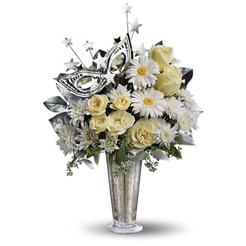 Toast of the Town [T132-3A] - What a delightful way to bring in the New Year! This fun and fabulous arrangement will light up the celebration long past midnight. It's glittery, glamorous and altogether a great choice.  So delightfully different, this bouquet shines with its stunning Mercury Glass Vase, silvery masquerade mask, a spray of silver stars and dazzling white roses, spray roses, miniature gerberas and more.  Approximately 13&quot; W x 18&quot; H  Orientation: One-Sided      As Shown : T132-3A