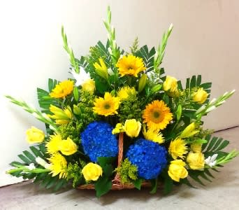  BLUE AND GOLD FIRESIDE BASKET  - BLUE AND GOLD BASKET ARRANGEMENT  ON THE ORDER FORM FOR DELIVERY INFO: Enter the FIRST AND LAST NAME of the deceased and select &quot;FUNERAL HOME&quot; under Location Type. Enter &quot;ANC&quot; under Funeral Home Name, and enter the SECTION-GRAVE NUMBER under Funeral Home Address. Use &quot;ARLINGTON, VA 22211&quot; for the City, State, Zip and enter YOUR CONTACT NUMBER for the Day Phone number. The delivery fee will change from $12.95 to $10.95 at final checkout. A complimentary delivery confirmation photo will be sent to your email address.      As Shown : TT-ANC36 