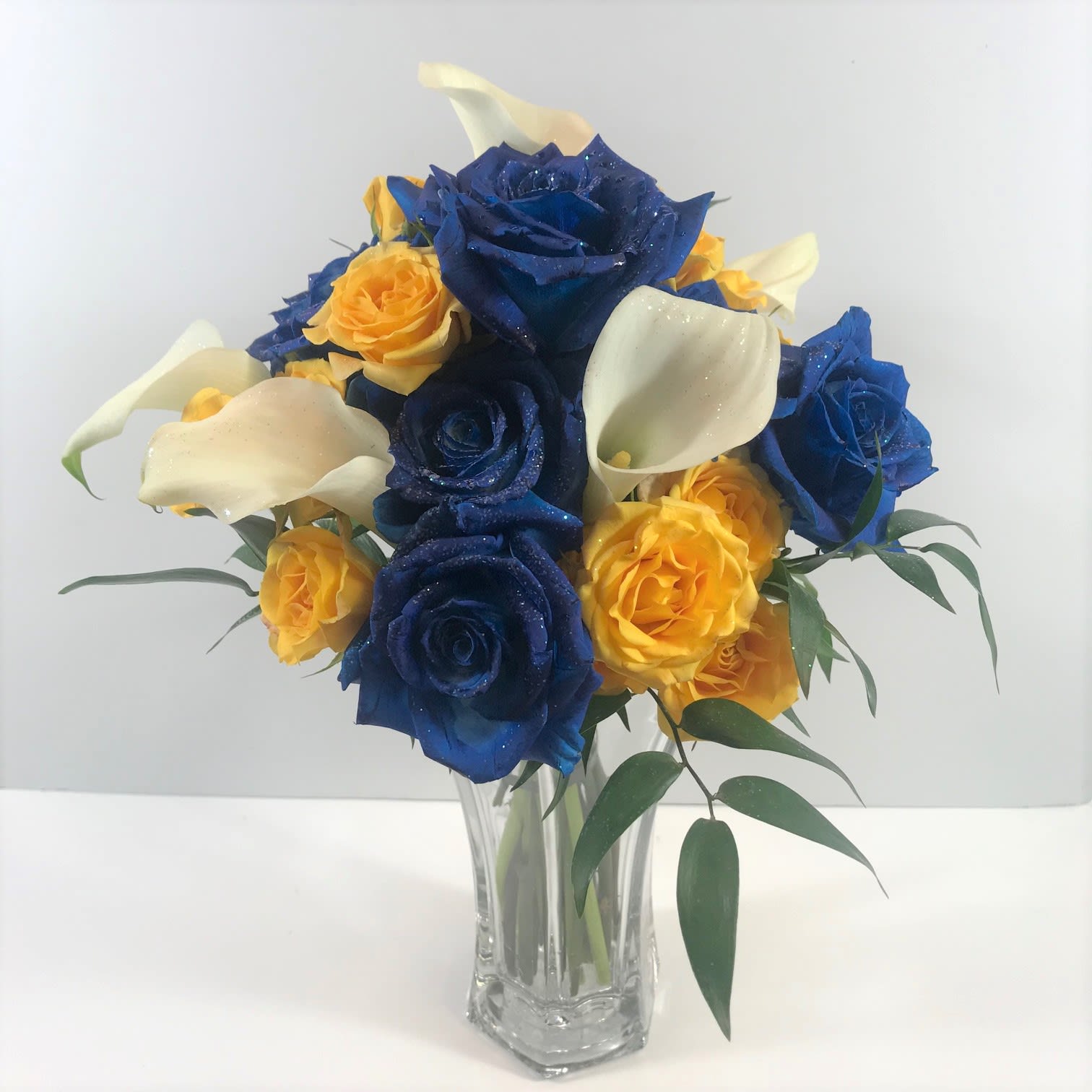 C48 Prom clutch with Calla Lilies C48 Prom clutch with Calla Lilies - This clutch shows "sprayed" roses in blue, yellow spray roses and stunning calla lilies. We customize your order to coordinate with your beautiful girl's dress.
