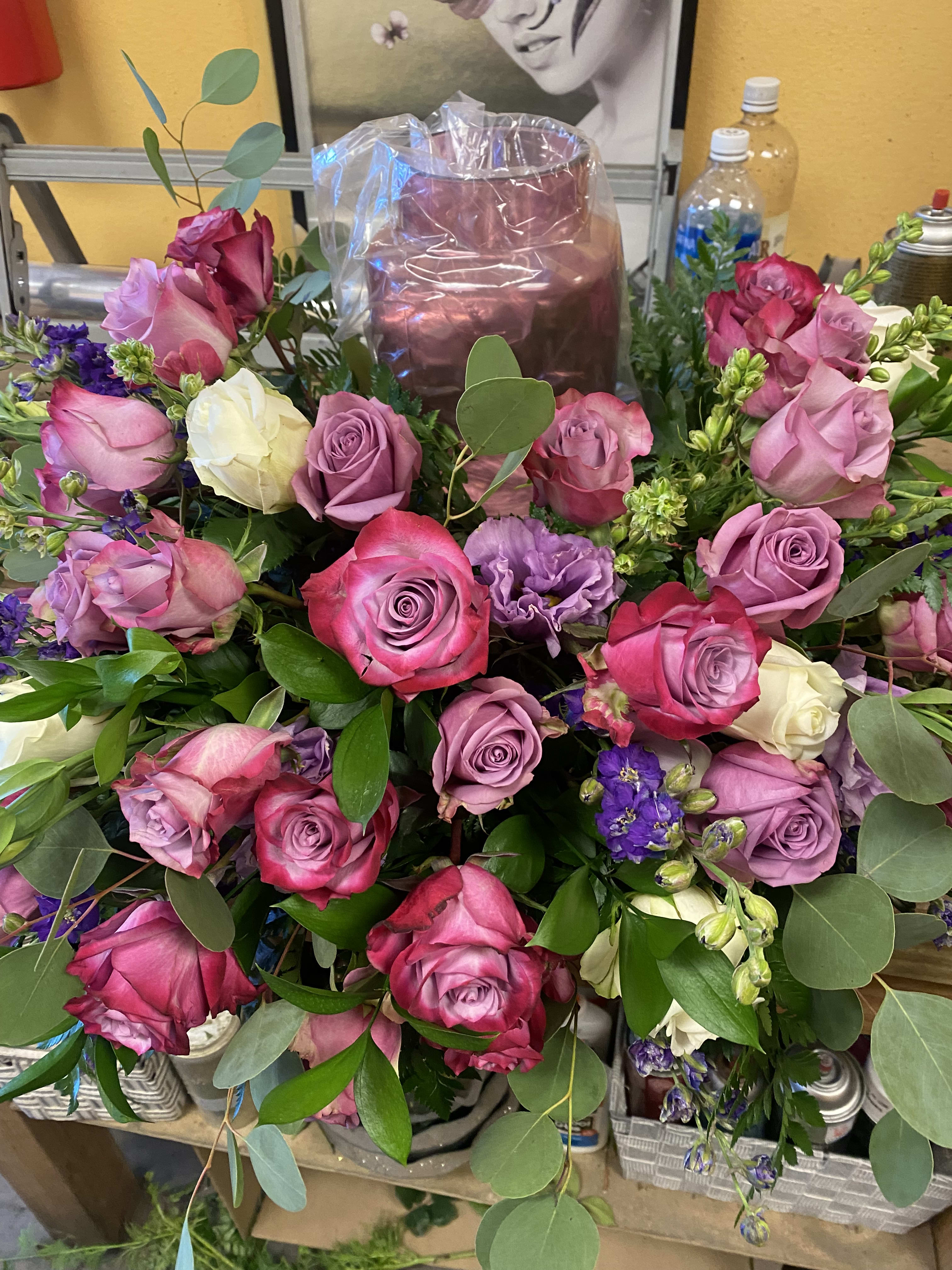 URN CENTERPIECE (Purple and White Flowers) Designer Choice URN CENTERPIECE (Purple and White Flowers) Designer Choice - A mixture of purple roses, white roses, purple larkspur, lisianthus, and silver dollar eucalyptus NOTE VASE SHOWN Is not included is just to show u how it's going to look.