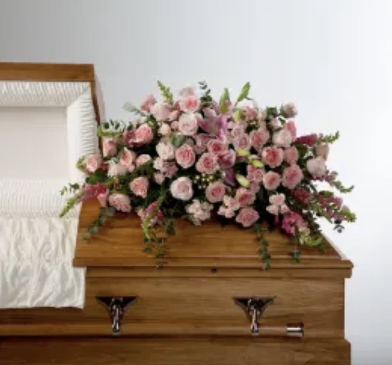 Tender Heart  - Roses, lilies, and more come together for a blushing pink half casket spray. Sized to fit both open and closed caskets. 
