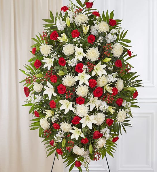 Red &amp; White Sympathy Standing Spray - A warm embrace. A kind word. A memorable gesture. There are many ways to express how we feel after the loss of a loved one. Our classic standing spray arrangement is elegantly crafted with radiant red roses and peaceful white blooms, offering care and support when it’s needed most.  One-sided standing spray arrangement with red roses, carnations and hypericum, white Asiatic lilies, football mums, stock and monte casino; accented with assorted greenery LARGE arrangement measures approximately 60&quot;H x 40&quot;W without stand MEDIUM  arrangement measures approximately 56&quot;H x 38&quot;W without stand SMALL measures approximately 46&quot;H x 34&quot;W without stand  Arrives on an easel Appropriate for the funeral home or gravesite Our florists hand-design every arrangement, so colors and varieties may vary due to local availabilit