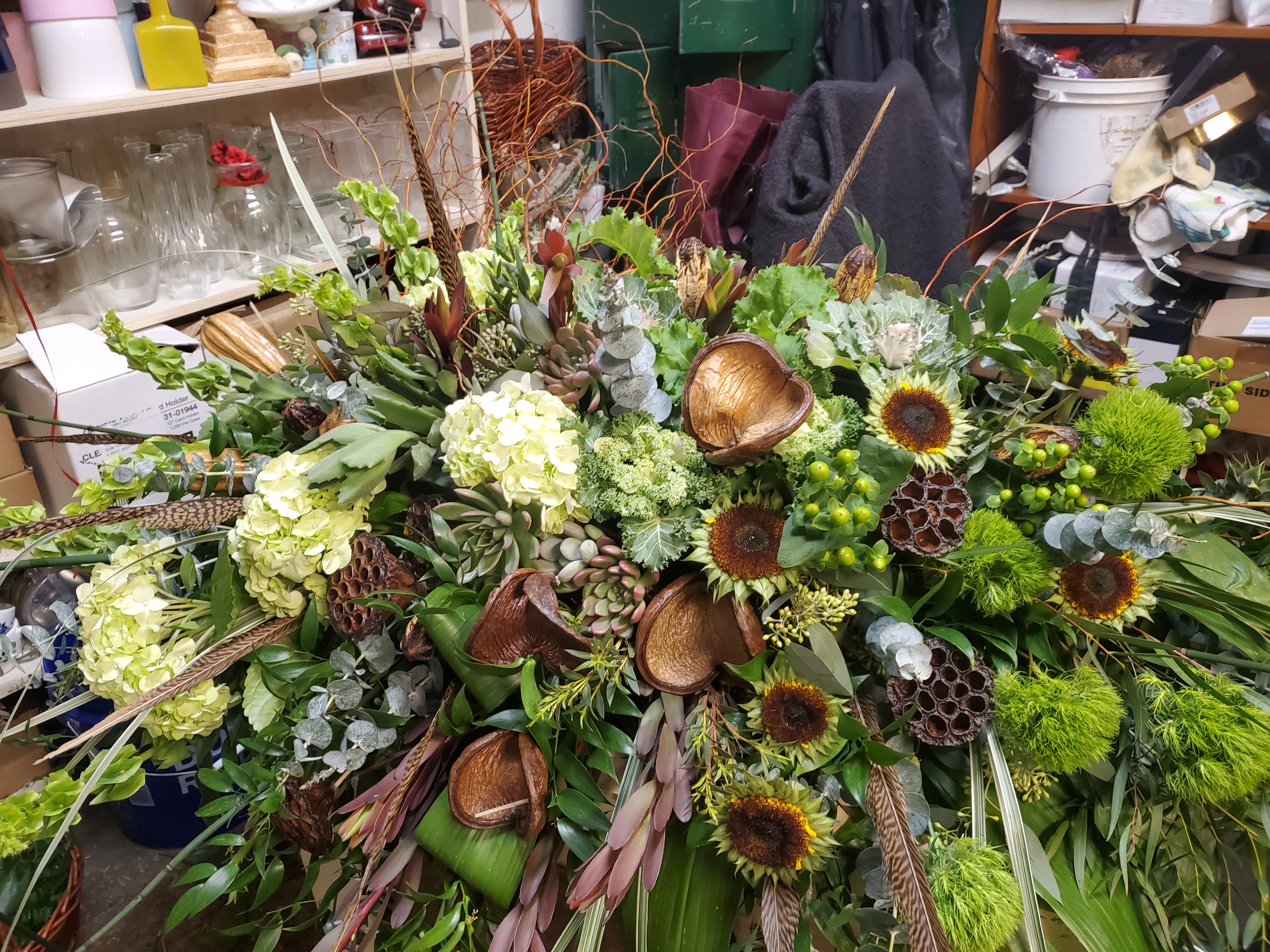 NATURE'S SERINITY NATURE'S SERINITY - CASKET SPRAY OF HYDRANGEA, ROSES, SUNFLOWER PODS AND BELLS OF IRELAND WITH NATURAL WOOD TOUCHES