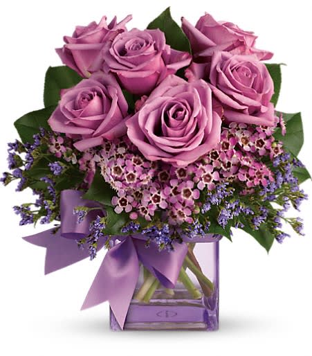 Morning Melody - Shades of purple are in perfect harmony in this profoundly pretty arrangement. A lovely mix of classic and modern, ribbons and roses, it's sure to make someone's day!  Lavender roses and waxflower, purple limonium and greens are hand-delivered in a lavender cube that's all wrapped up with a vibrant purple taffeta ribbon. Approximately 10 1/2&quot; W x 11&quot; H