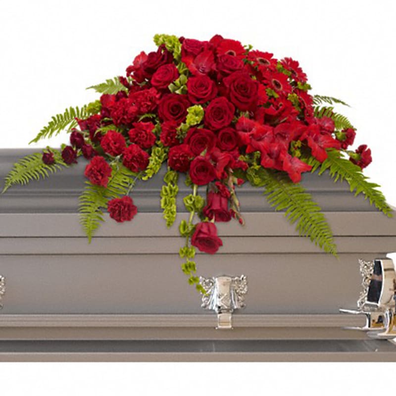 Red Rose Sanctuary Casket [T230-3A] - A gorgeous mix of dazzling red flowers will make a grand, yet graceful impression.  Beautiful red roses, spray roses, gerberas, gladioli and carnations along with vibrant green bells of Ireland create a sincere tribute.  Approximately 40&quot; W x 27&quot; H  Orientation: N/A  As Shown : T230-3A