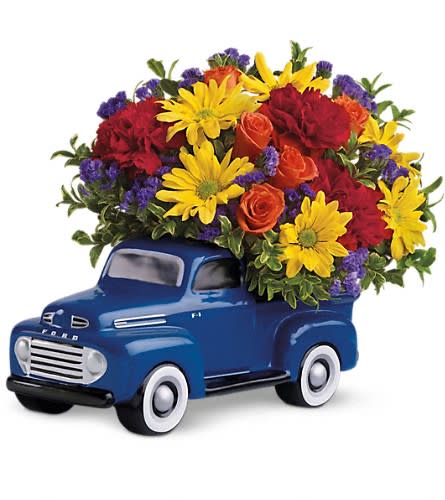Teleflora's '48 Ford Pickup Bouquet Teleflora's '48 Ford Pickup Bouquet - Put the pedal to the metal and order this truck full of flowers for your favorite guy today! This brilliant blue pickup is a replica of the classic 1948 Ford F-1. Fabulous and festive it will surely be displayed and cherished for years. A great guy gift. Birthdays. Father's Day. Any day. Orange spray roses red carnations yellow daisy spray chrysanthemums purple statice and more are all delivered in a terrific truck that just happens to come with its bed full of flowers.Approximately 13" W x 9 1/2" H