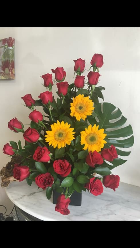 My Eyes over You - Luxury and elegant arrangement with 24 Red Roses, 3 Sun Flowers and a tropical Touch with a Monstera, great to make a huge impact with your Love