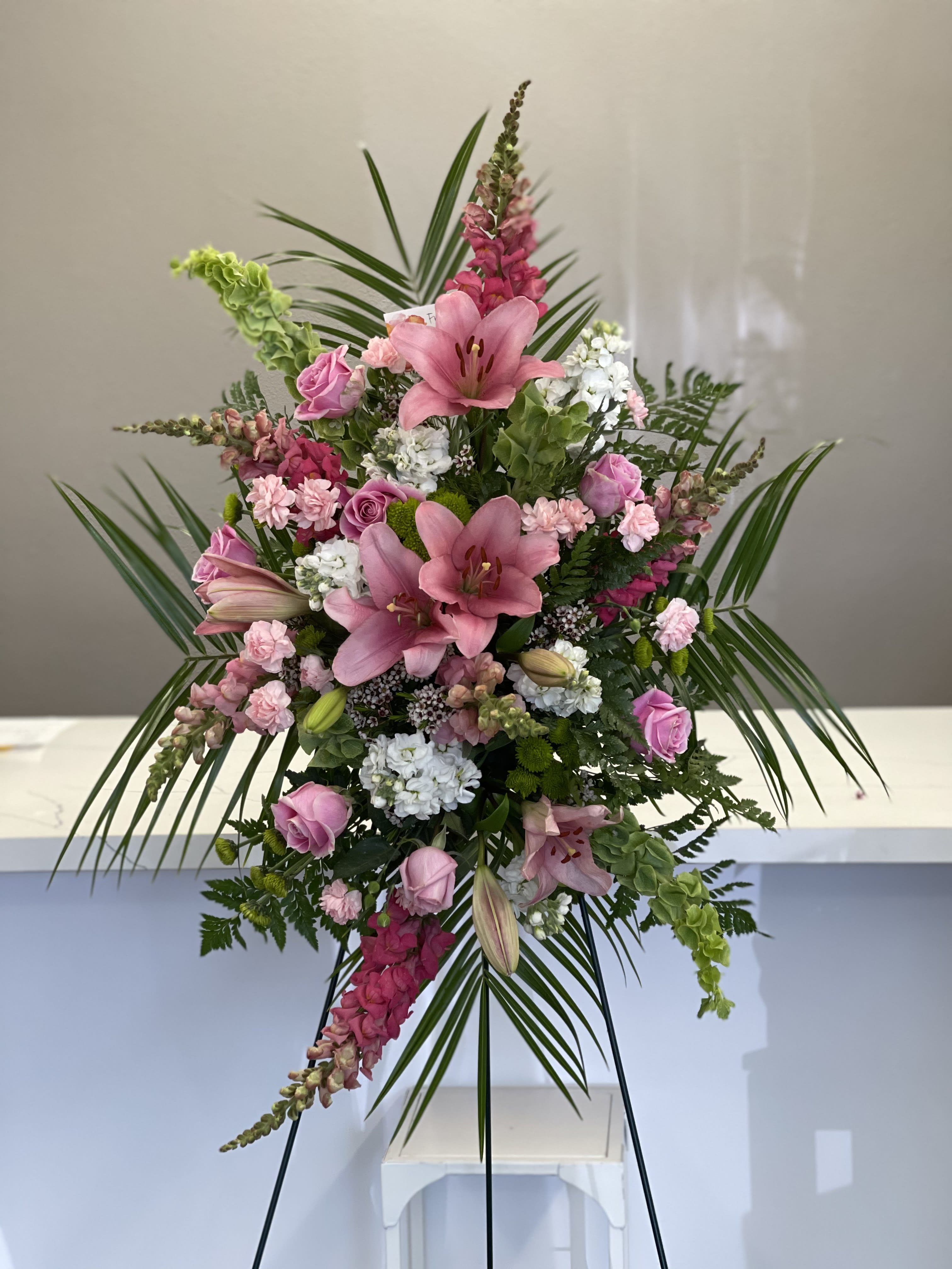 Rosy Life  - This standing spray is designed to honor the life of your loved one with fresh pink blooms and a tropical twist. 