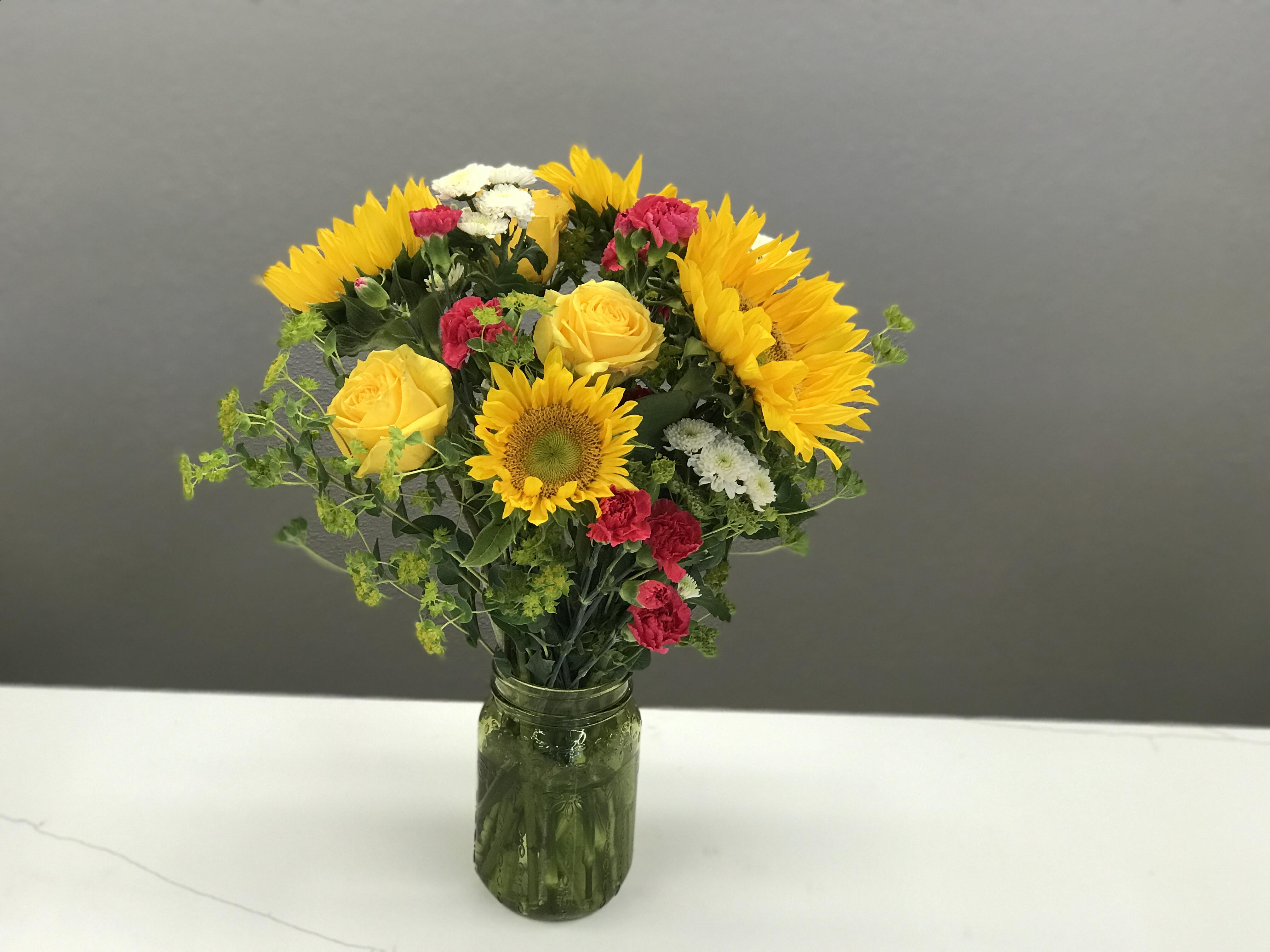 Farm to Table Farm to Table - This happy arrangement is housed in a quaint mason jar, giving the feel that you ran out to garden and picked them personally for your loved one.