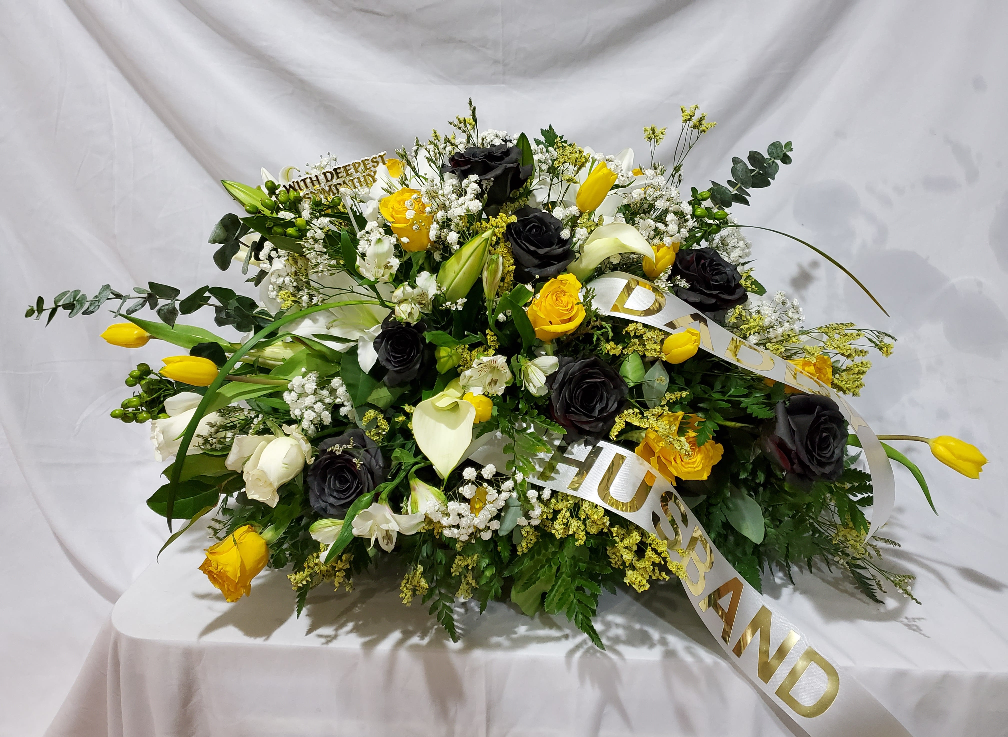 Remembering you - A custom casket spray sympathy and funeral arrangements. Colors yellow, black, white.