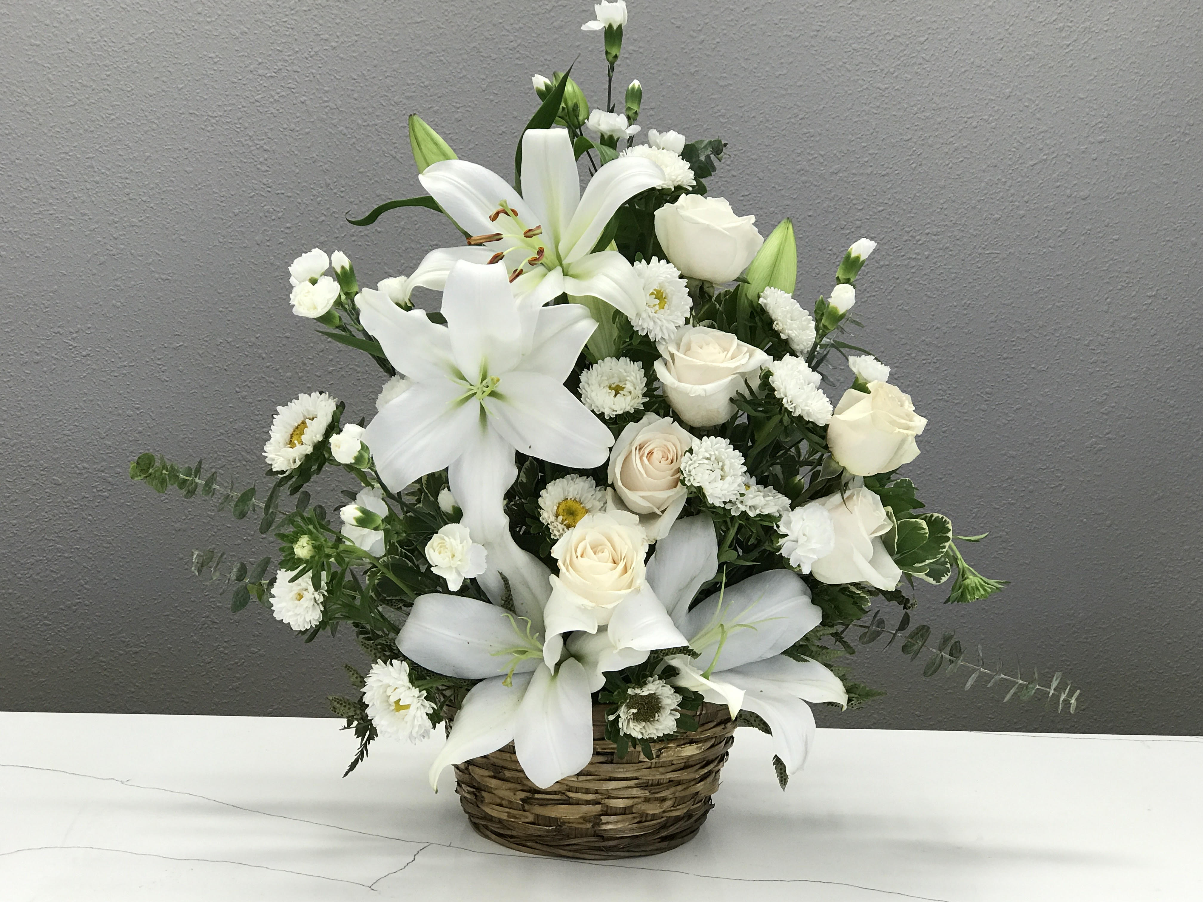 Forever Yours - A basket of white lilies, roses, and matsumoto asters to honor the life of your loved one. 