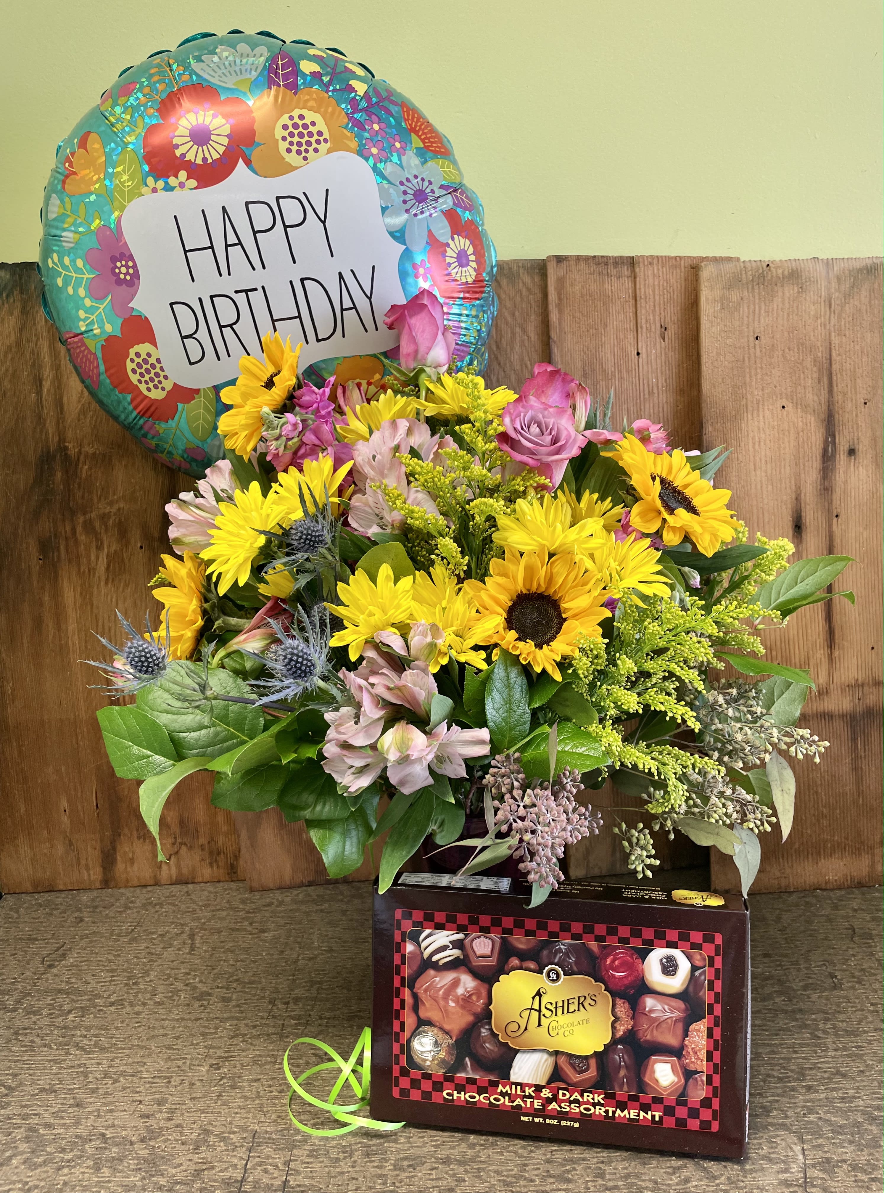 Happy Birthday Bundle - Celebrate someone special on their special day!! Festive fresh flower vase combines with a mixed box of chocolates and a festive mylar balloon to really spoil the recipient! Regular shown. Upgrades are to flowers. All choices include one mylar and one 8 oz. box of chocolates. Vase and balloon will coordinate and reflect the season and gender of recipient. Photo shows general look and feel of a typical, seasonal birthday vase. Specify preferences in special instructions if necessary.