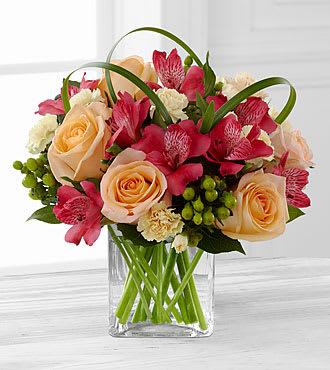 The FTD® All Aglow™ Bouquet by Better Homes and Gardens®  - FTD® proudly presents the Better Homes and Gardens® All Aglow™ Bouquet. Light up their life with incredible color and blooming beauty when you send this exquisite flower bouquet. Unforgettable peach roses are surrounded by red Peruvian lilies, pale yellow mini carnations, green hypericum berries, lily grass blades, and lush greens to create a stunning flower arrangement. Presented in a clear glass cube vase to give it a sophisticated look, this mixed flower bouquet will express your sweetest thank you, get well, or congratulations wishes. Is approximately 10&quot;H x 11&quot;W as shown.