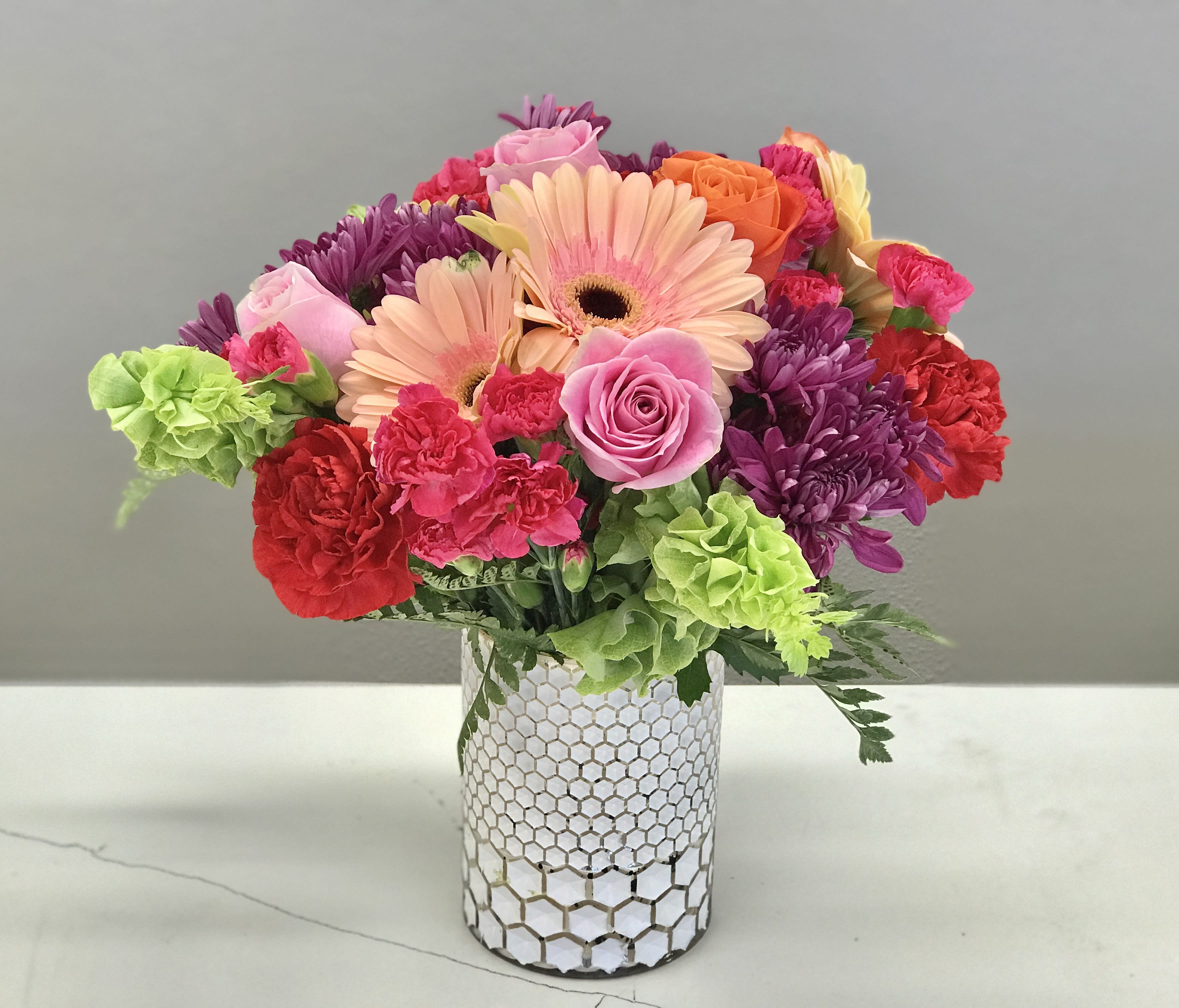 Candy Jar - Colorful blooms full of spilling over remind one of reaching into grandma's bon bon tin. Send a virtual hug with this bright and playful bouquet. 