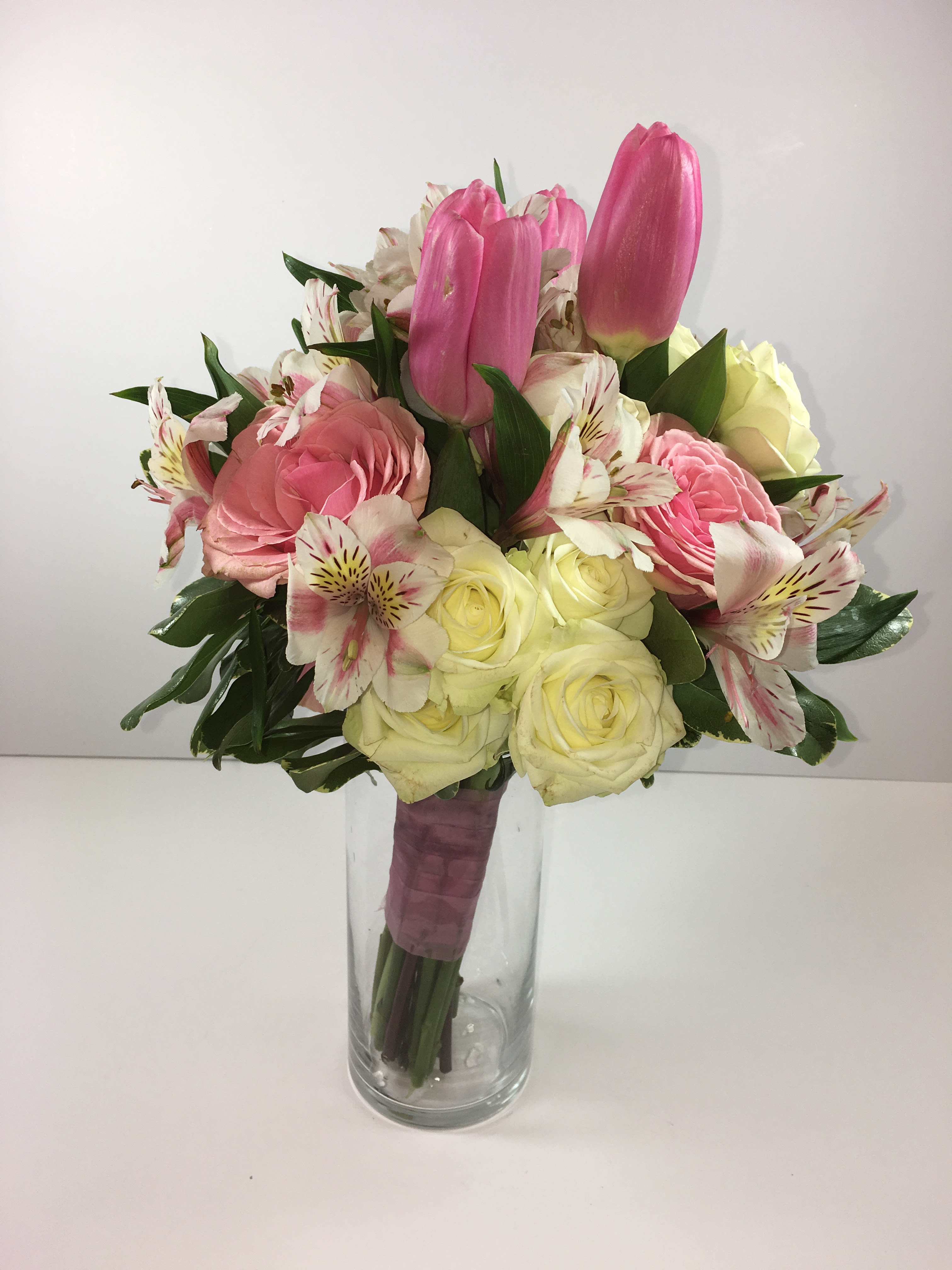 C30 Mixed floral clutch - This stunning clutch includes roses, spray roses, alstroemeria and accented with tulips.  Each clutch is customized for your date and her amazing dress.