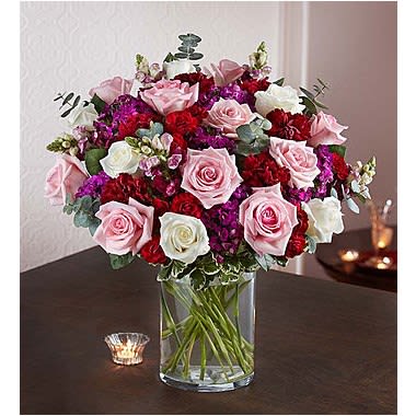 1-800-Flowers® Victorian Romance™ 1-800-Flowers® Victorian Romance™ - Our lush & elegant bouquet calls to mind a time of long, romantic courtships. Hand-gathered inside a sleek glass cylinder vase, this rich gathering of blooms creates a beautiful expression of love spoken in the language of flowers. •All-around arrangement with pink and white roses; burgundy carnations, mini carnations and snapdragons; purple dianthus; accented with spiral eucalyptus and variegated pittosporum •Artistically designed in a clear glass cylinder vase; measures 8""H •Large arrangement measures approximately 18"H x 13"L •Medium arrangement measures approximately 17"H x 12"L •Small arrangement measures approximately 16"H x 11"L •Our florists hand-design each arrangement, so colors and varieties may vary due to local availability