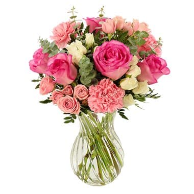 Bloom Envy Bouquet - Mom will almost certainly invite all her friends to see this bright and beautiful bouquet…then watch with glee as envious expressions appear on their faces. Roses, mini carnations and eucalyptus are imaginatively arranged in a swirl glass vase.
