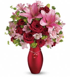 Teleflora's Charm Her Bouquet - The perfect 3-in-1 gift. She'll love the romantic bouquet, cherish the chic vase, and wear the dazzling glass heart pendant for years to come. An enchanting three-in-one gift that will win her heart over and over again.  Red roses, red spray roses, pink Asiatic lilies, light pink alstroemeria, pink carnations and bupleurum accented with assorted greenery arrive in a lustrous red ceramic vase with a stunning glass heart pendant necklace.  Approximately 15&quot; W x 18&quot; H  Perfect 3-in-1 gift: Includes bouquet, vase and dazzling glass heart pendant necklace! This gorgeous red ceramic vase and glass heart pendant necklace are from Teleflora's celebrated Flowers-in-a-Gift collection. She'll love them both for years to come. Orientation: One-Sided