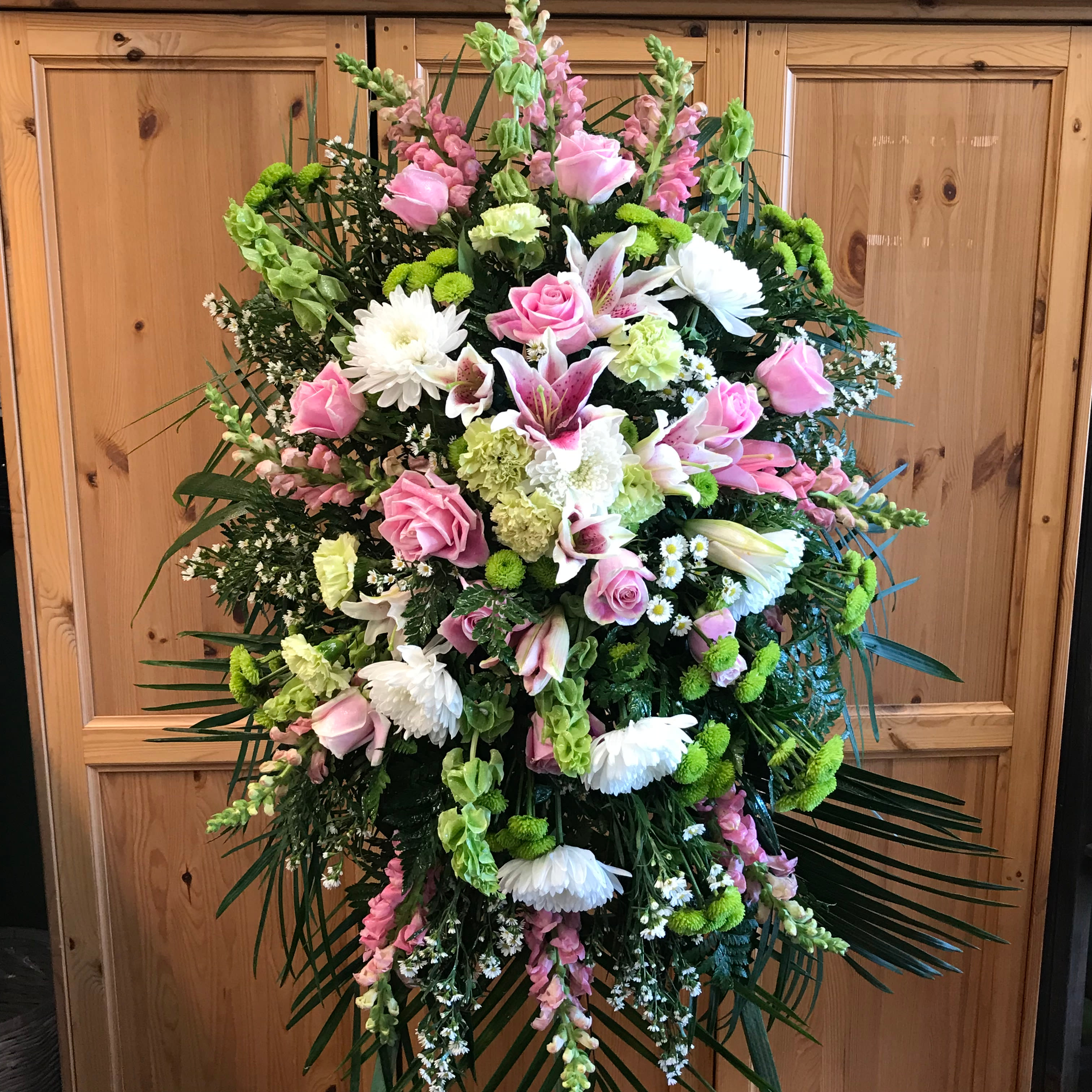 Thoughtful Prayers - Mixed flower Standing Spray. Soft colors of pink, white, green, and lavander.