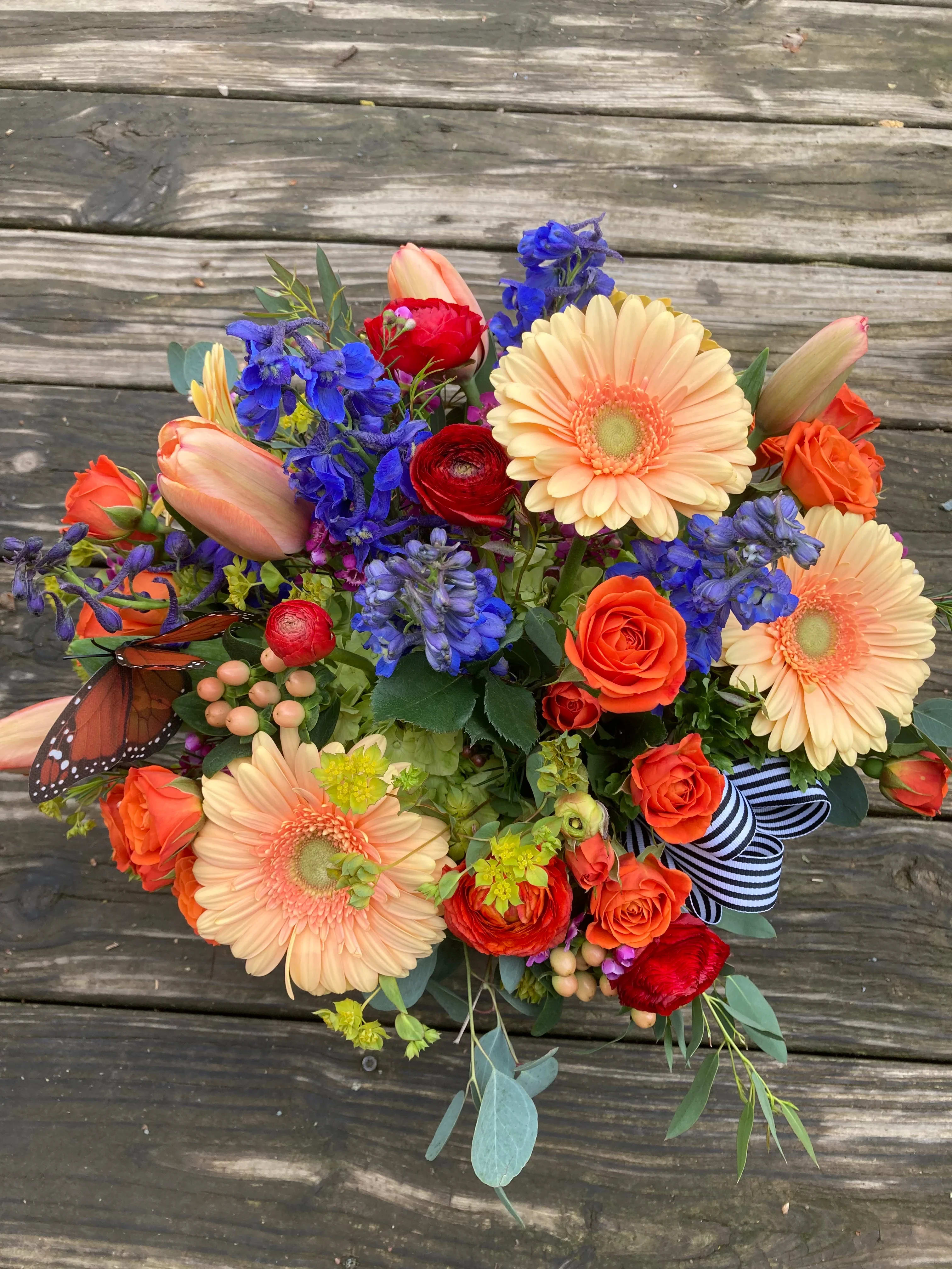 Summer Pleasures - A colorful mixed bouquet with gerberas, delphinium, ranunculus, and spray roses.