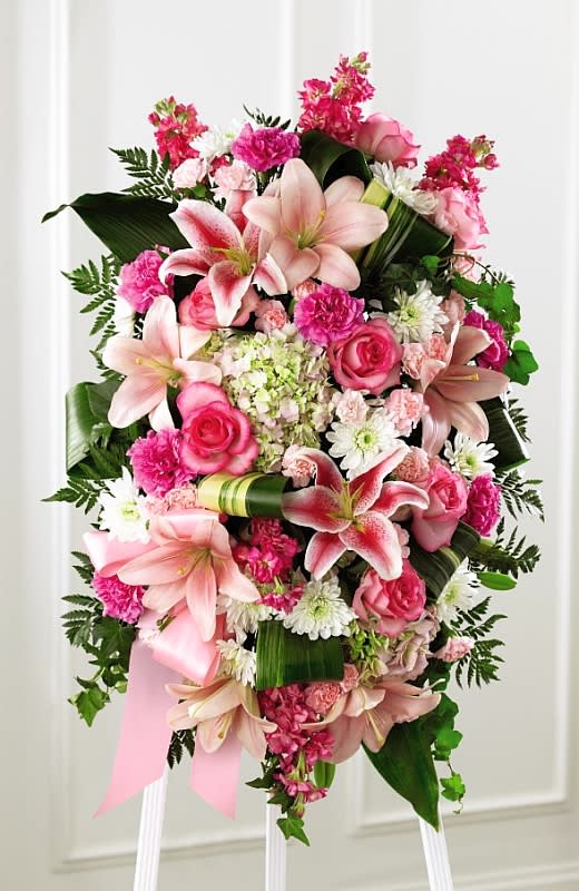 Gently into the Ever-After Spray Gently into the Ever-After Spray - Bright, fresh, beautiful and just right for an elegant expression of heartfelt sorrow and devastating loss. This classic standing arrangement is constructed of hand-selected pink blossoms ranging from pale pastels to deep blushing pink. It includes roses, carnations, stock, cushion pompons, Asiatic and Stargazer lilies and hydrangea beautifully set among a field of lush contrasting greens like aspidistra and ivy vines. It makes an impressive memorable tribute at a wake, funeral or graveside service.