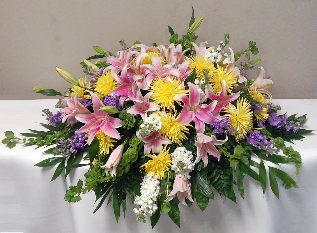 The Pastel Garden Casket Spray The Pastel Garden Casket Spray - The Pastel Garden Casket Spray is a Designers Choice of assorted pastels color flowers similar to the image to include lilies, stock, spider mums while keeping the same look and feel.