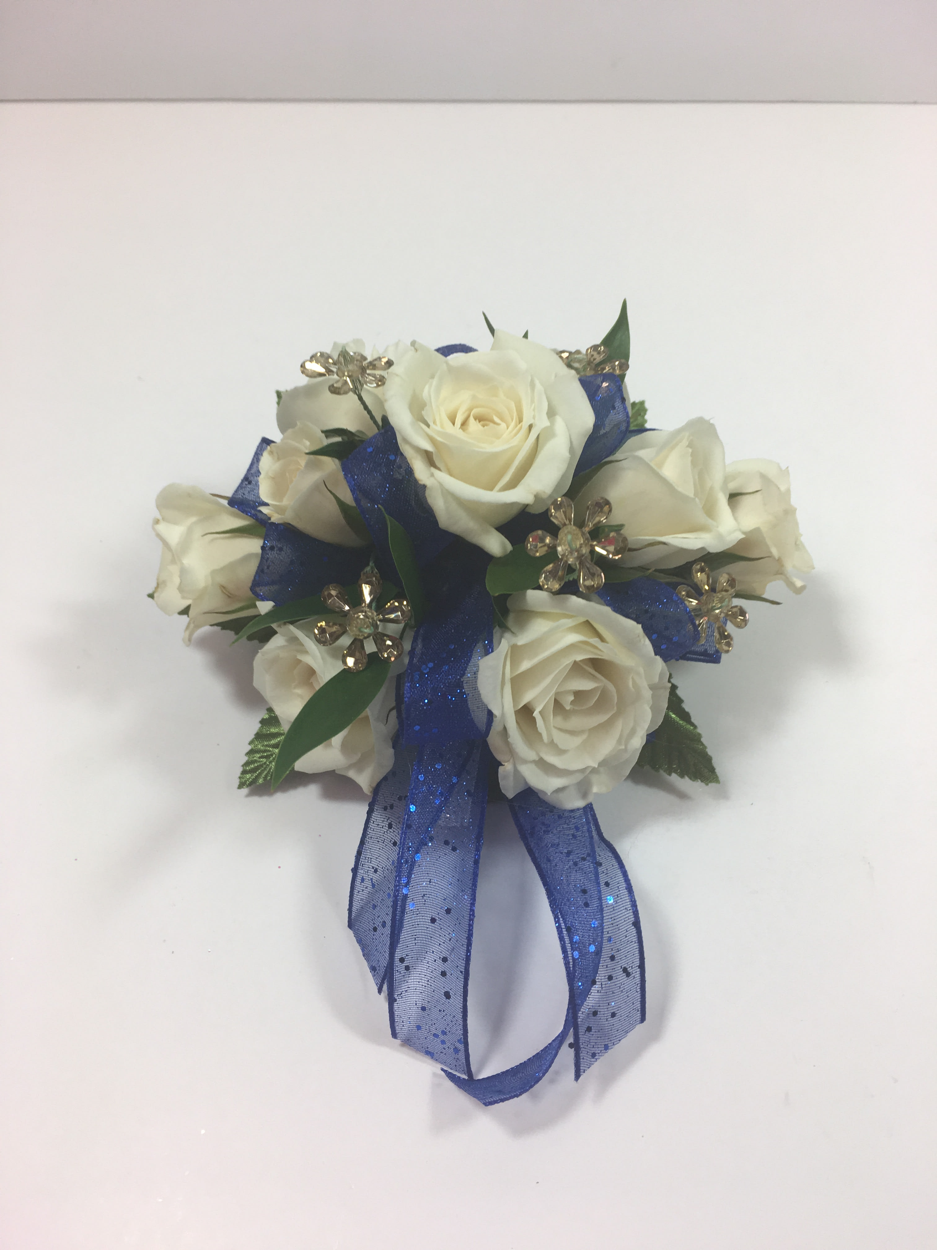 W8 White Spray Rose Corsage  - Wristlet corsage of white spray roses with royal bow and gold bling.  Each prom order is customized for your girl and her beautiful dress.