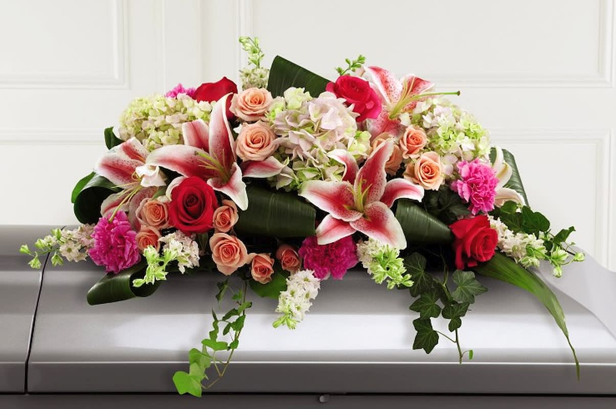 Splendid Grace Casket Spray - An extraordinary way to pay your respects to someone very close, this colorful mixed flower casket spray beautifully delivers your sincere expression of love and sympathy. Traditionally ordered by the deceased’s immediate family, this casket enhancement includes larkspur, roses, carnations, hydrangeas and Stargazer lilies complemented with lush greens salal and ivy vines. It’s made to fit over the closed portion of a casket cover during visitation at a funeral home. 