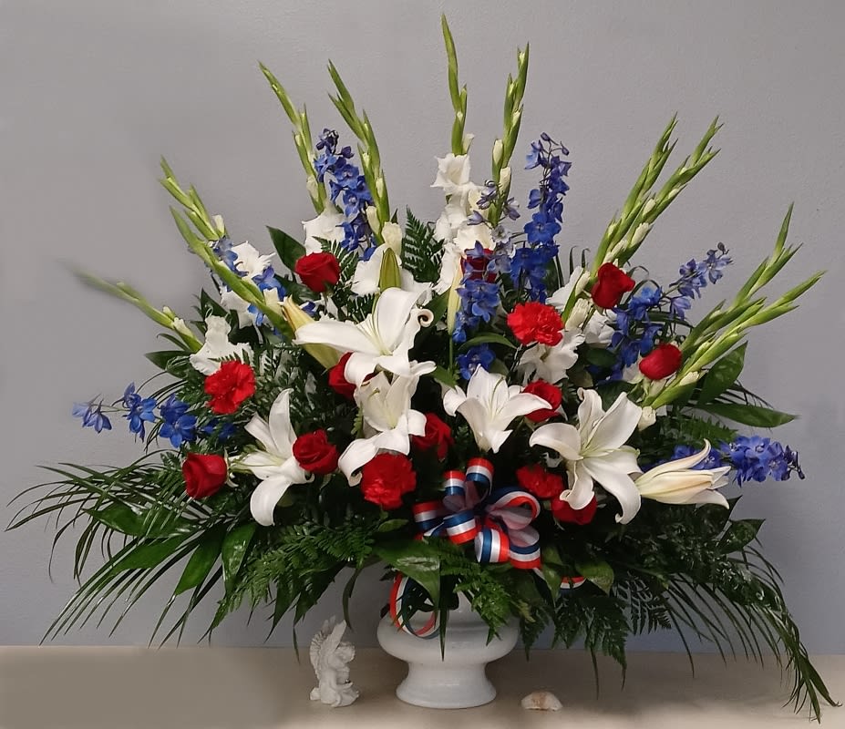 Red White & Blue Urn Red White & Blue Urn - This patriotic urn is full of red white and blue flowers that honors veterans and all patriotic Americans and goes nicely on the pedestal next to the flag draped coffin sometime in pairs on either side.