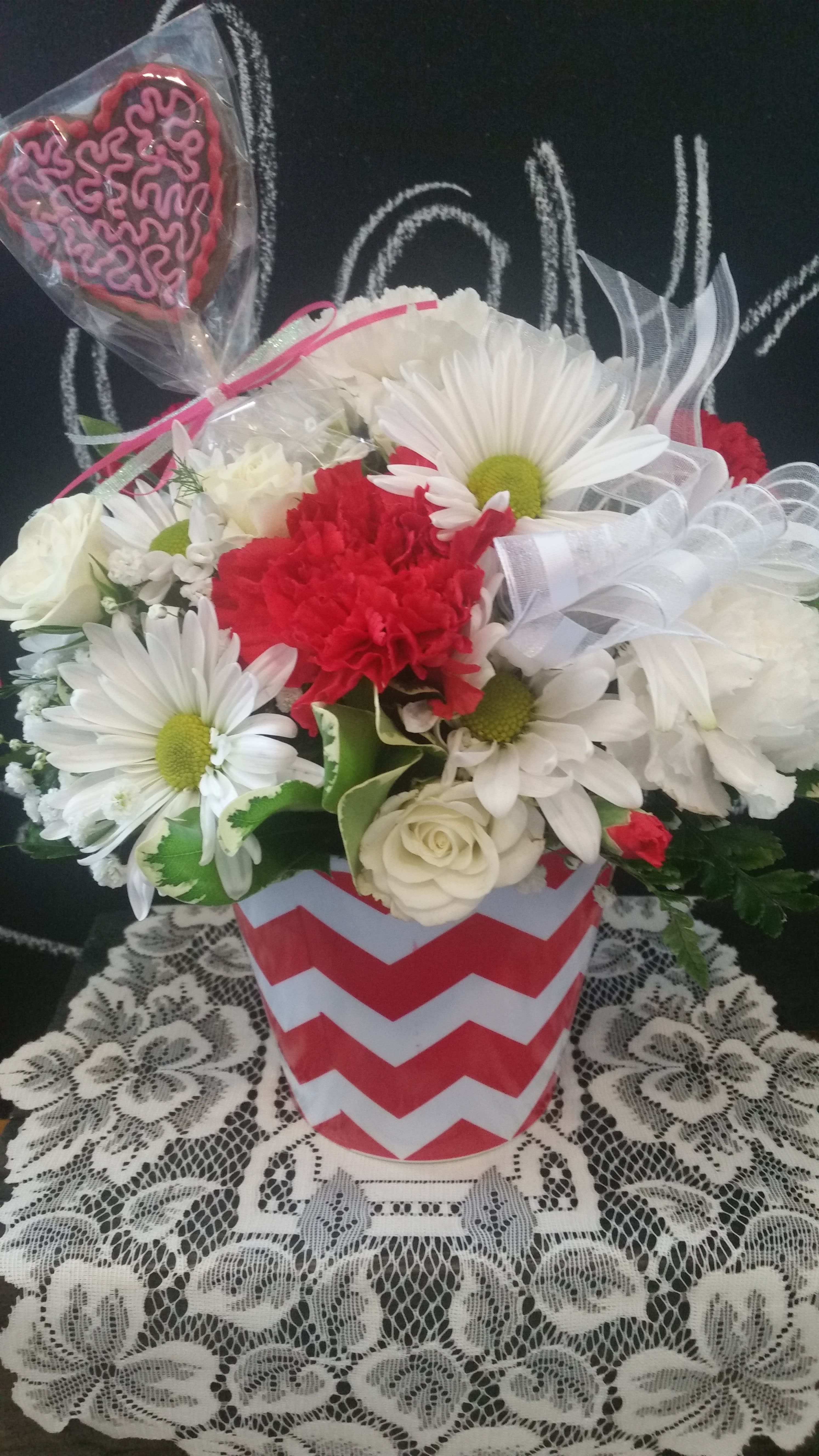 The Heartbeat - This cute flower arrangement is filled with a variety of fresh flowers and a chocolate heart sucker. 