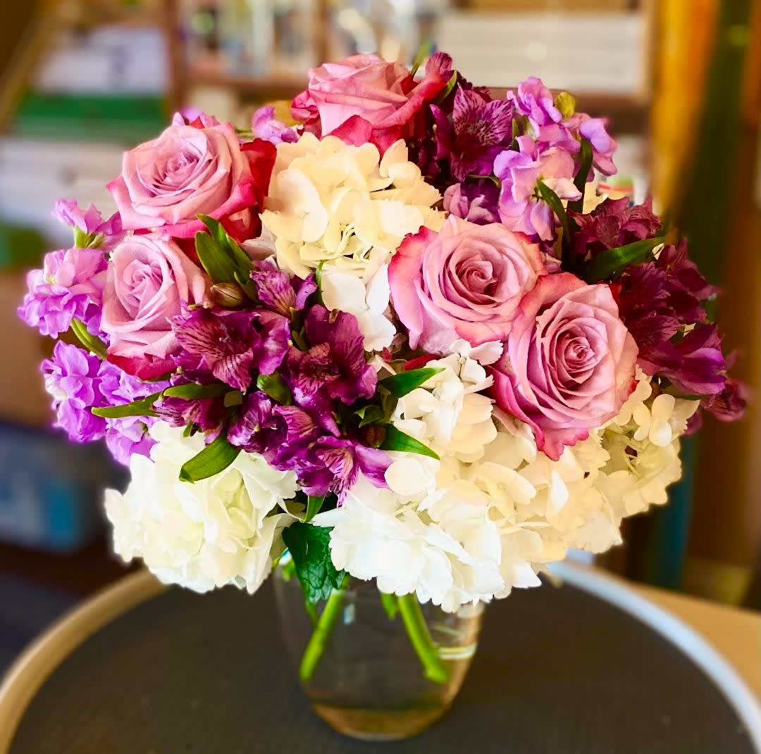 Amethyst Dreams Amethyst Dreams - This arrangement is composed of various purple and lavender blooms, nestled in beautiful lush white Hydrangeas. This vase arrangement includes Hydrangeas, Roses, Stock, and Alstromeria. This design measures approx. 12"W x 16"H.