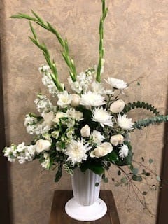Peace Be With You Always Peace Be With You Always - Type of Flowers: White Stock, Fuji Mums, Eucalyptus, Astro Érica Roses, Gladiolus, Alstroemeria in a tall white vase. Availability: All year round Photo shown: Regular