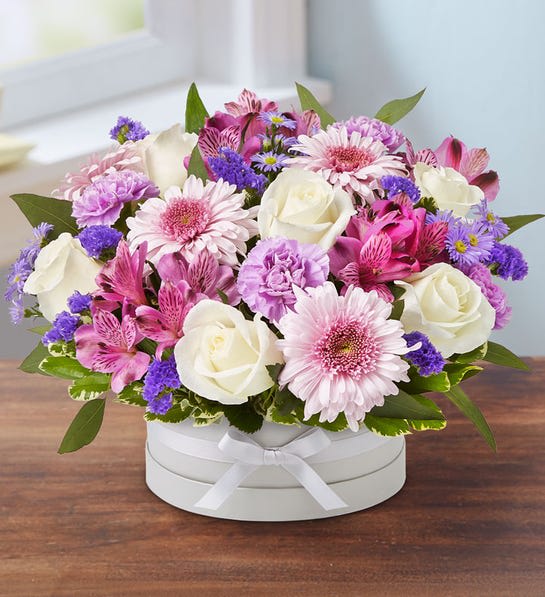 Victorian Hatbox - EXCLUSIVE An exquisite gift with elegant, Victorian style. Our lovely gathering of blooms is arranged in our signature European hatbox, a new, dove gray container finished with a matching ribbon. Its versatile design is perfect for displaying a variety of colors, adding a special touch to any occasion.