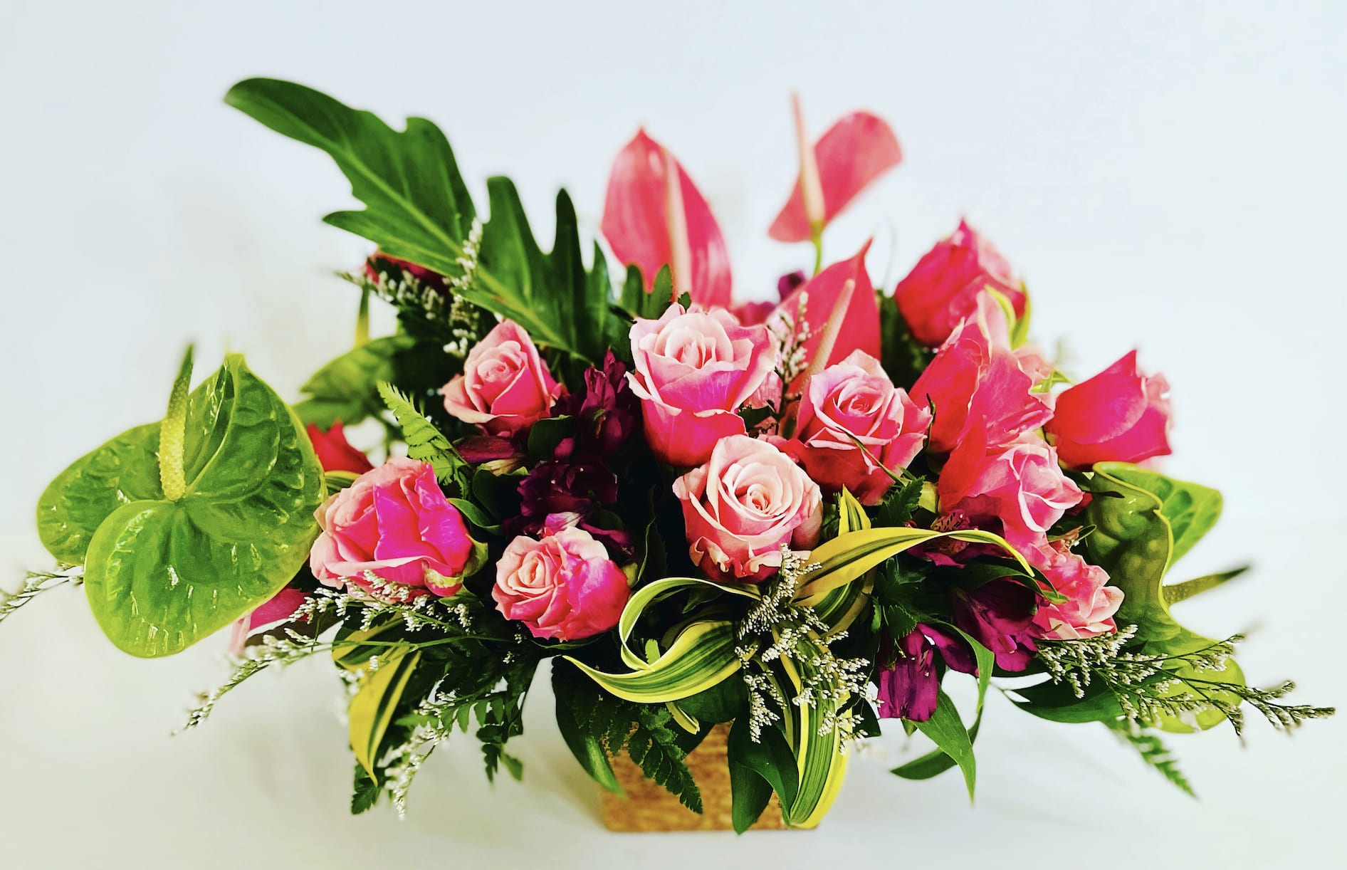 Tropical romance - Tropical blooms designed with modern accents of roses, seasonal blooms (based on availability) and tropical greens.    Designed to be viewed from all sides in a low profile vase.   All floral arrangments are designed to a style and use seasonal materials of varying content.  Please contact us directly for any custom orders or requests info@helemelebotanicals.com or 808.226.7667.  We are committed to malama 'aina and strive to use locally sourced material, reduce packaging and reuse and recycle where possible. We will pick up any of our product (vessels, plants and floral supply material) when delivering a subsequent order. At that time, a $5 credit toward future purchase will be issued for each ceramic, metal or wood vessel returned.