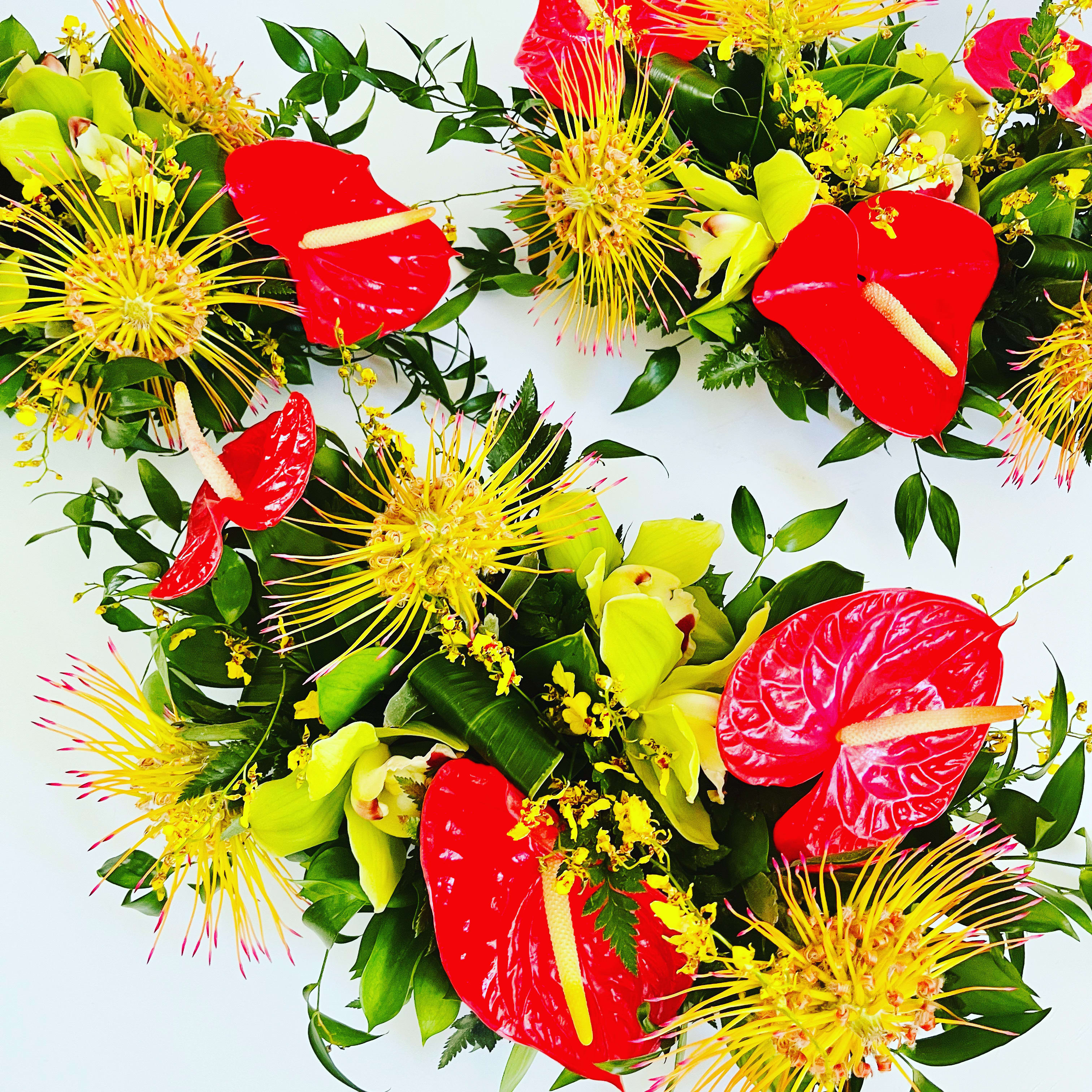 Tropical Trio - A trio of tropical centerpieces filled with colorful tropical blooms (based on availability) and tropical foliage. These pieces are designed in an unseen dish that sits flush on the table. We can design them to be long or round upon request.   Designed to be viewed from all angles.  Enhanced option includes additional blooms and foliage.  All floral arrangments are designed to a style and use seasonal materials of varying content.  Please contact us directly for any custom orders or requests info@helemelebotanicals.com or 808.226.7667  We are committed to malama 'aina and strive to use locally sourced material, reduce packaging and reuse and recycle where possible. We will pick up any of our product (vessels, plants and floral supply material) when delivering a subsequent order. At that time, a $5 credit toward future purchase will be issued for each ceramic, metal or wood vessel returned.