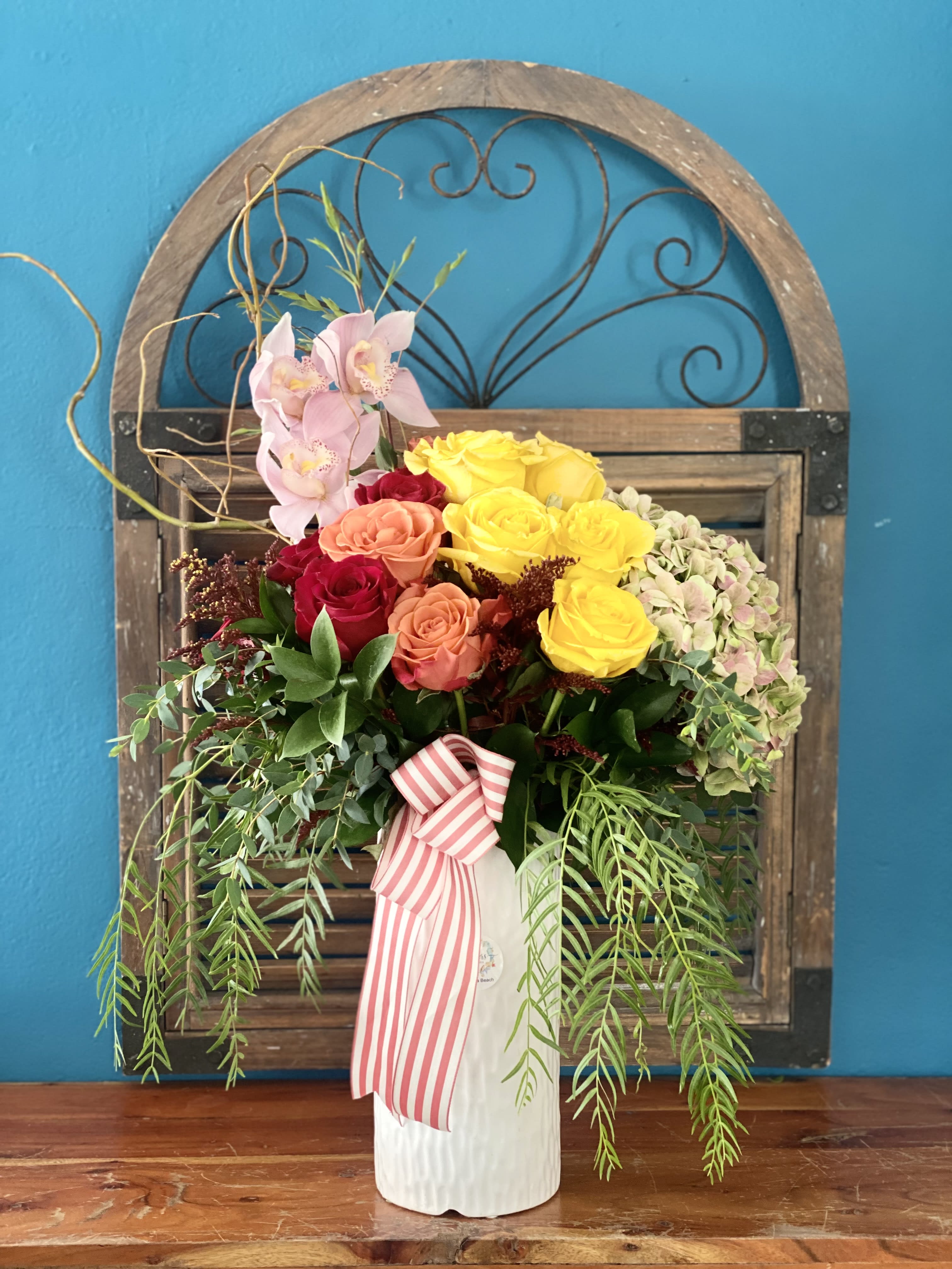 Roses and Foliages  - Multicolor roses bouquet in white ceramic vase with orchid and Hydrangea.