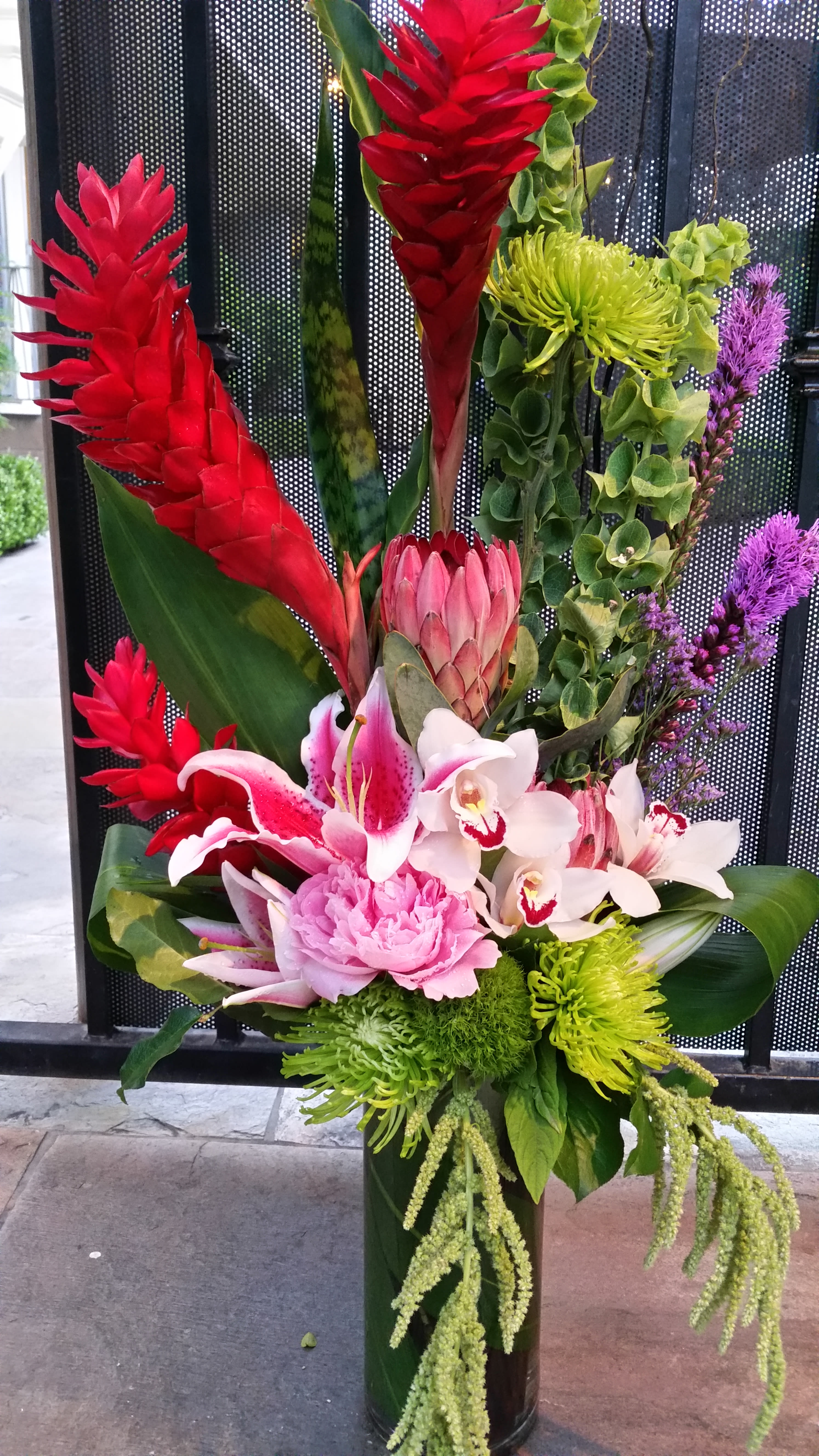 Ginger &amp; Proteas  - Ginger, Proteas, Lilies, Peonies, Tropical leaves. Arranged in tall glass vase.