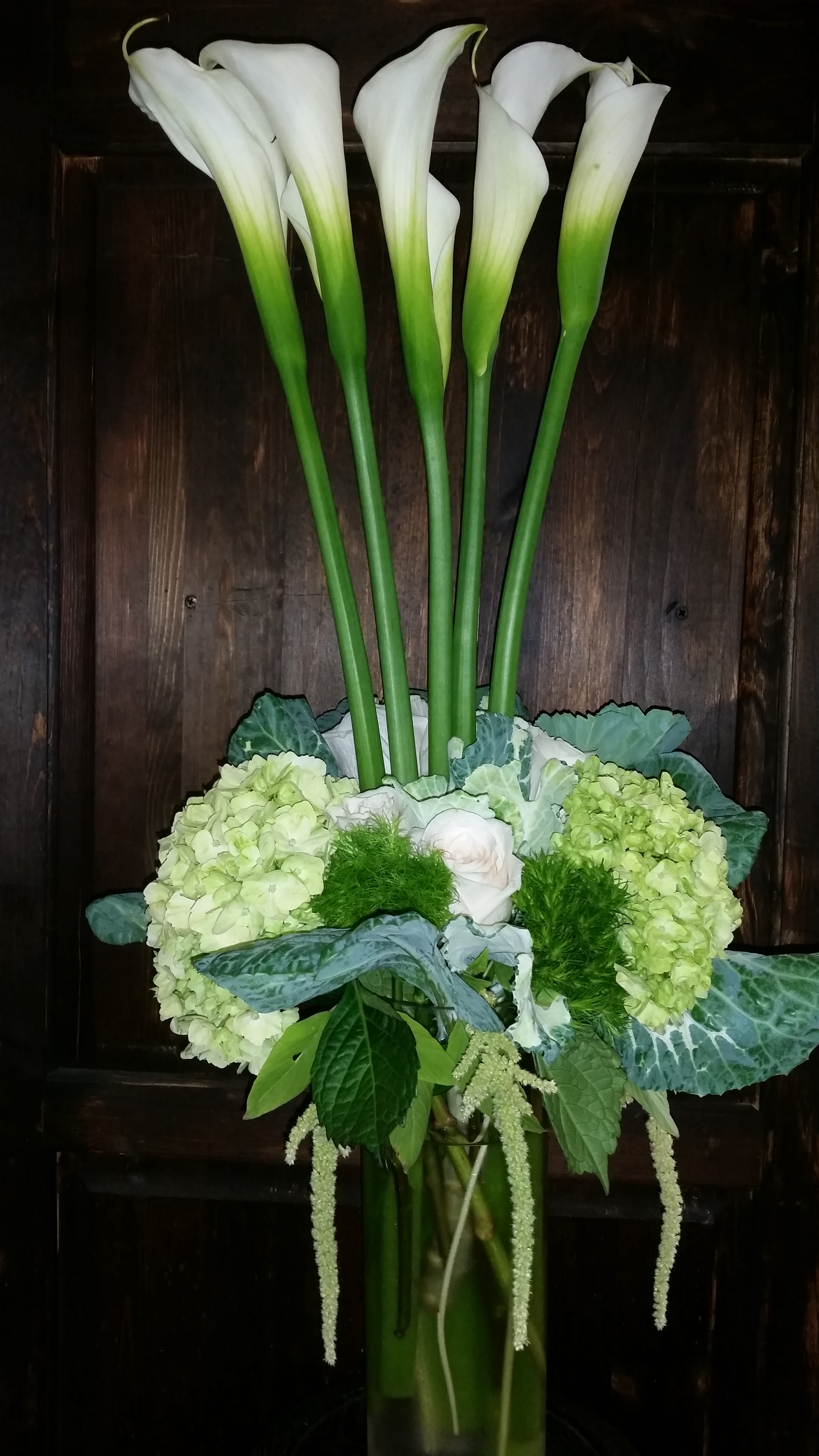 Calla Lilies Calla Lilies - calla lilies, green hydrangea,dianthus, roses, ornamental cabbage flowers,amaranthus. Arranged in tall clear vase