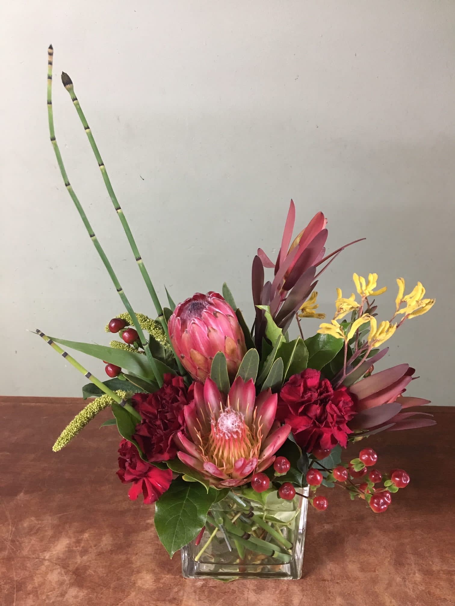 Tropical All In One  - Queen proteas, safari and mix tropical flowers arrange in a glass vase. 