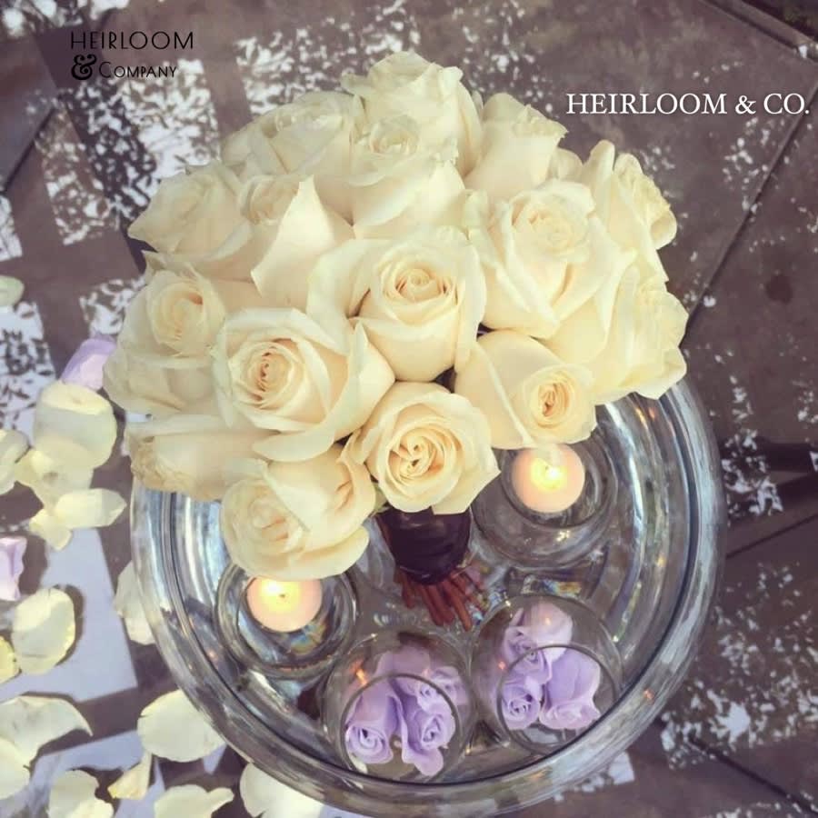 Floating On Love Floating On Love - This arrangement was designed with nothing but romance in mind. From the bouquet styled wrap of the white vendela roses, to the floating candles and decor, this one is sure to make a splash. Also available in the combination of red roses and white floating decor accents