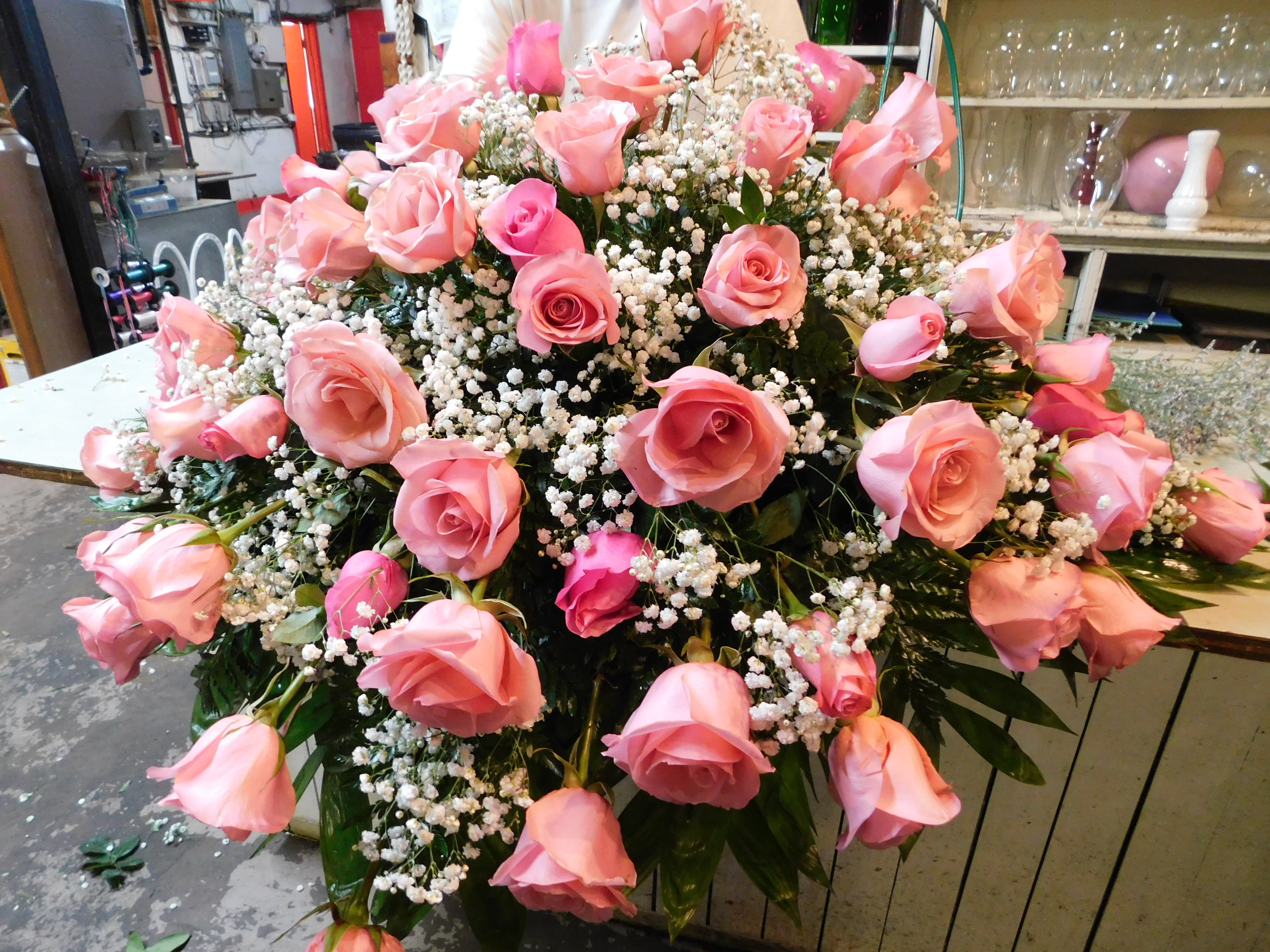 Rose casket spray -  A fresh, feminine symbol of hope for the service. This feminine spray features lovely pink roses with filler. Rose colors can also be chosen in Yellow, Red, Lavender, White, Pink or assorted colors. 