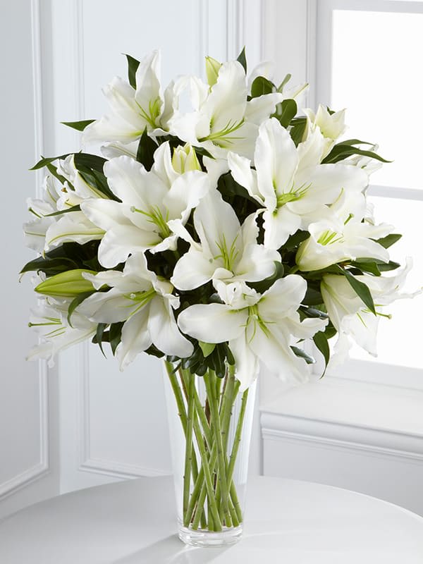 Light in your honor arrangment Light in your honor arrangment - Bouquet of gorgeous Oriental lilies are accented with lush greens and seated in a clear glass vase to create a bouquet that is serenely sophisticated, offering comfort and peace in their time of need. Approximate Size: 22″h x 15″w