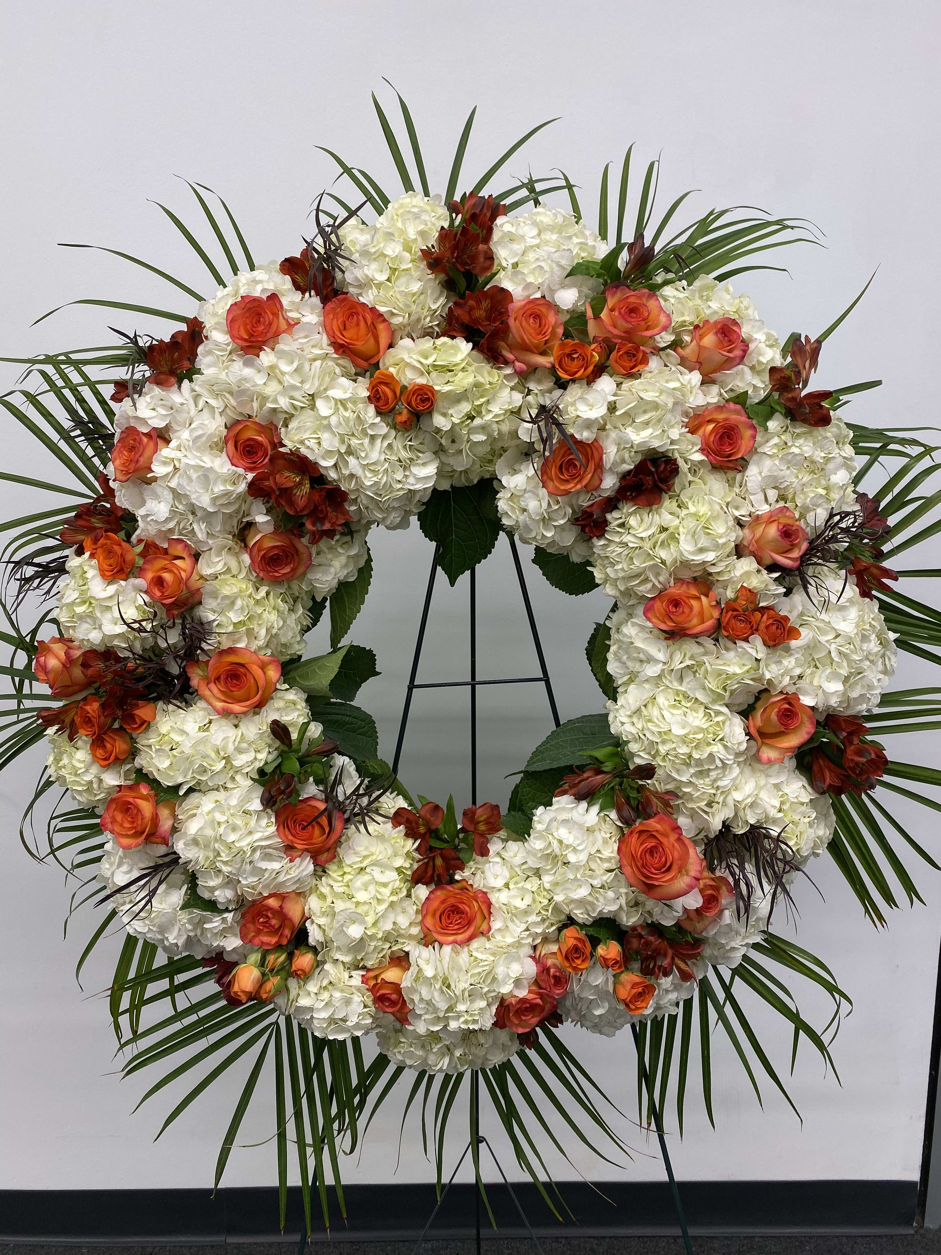 Peaceful in white and orange - Beautiful white and orange round spray on a tall easel.