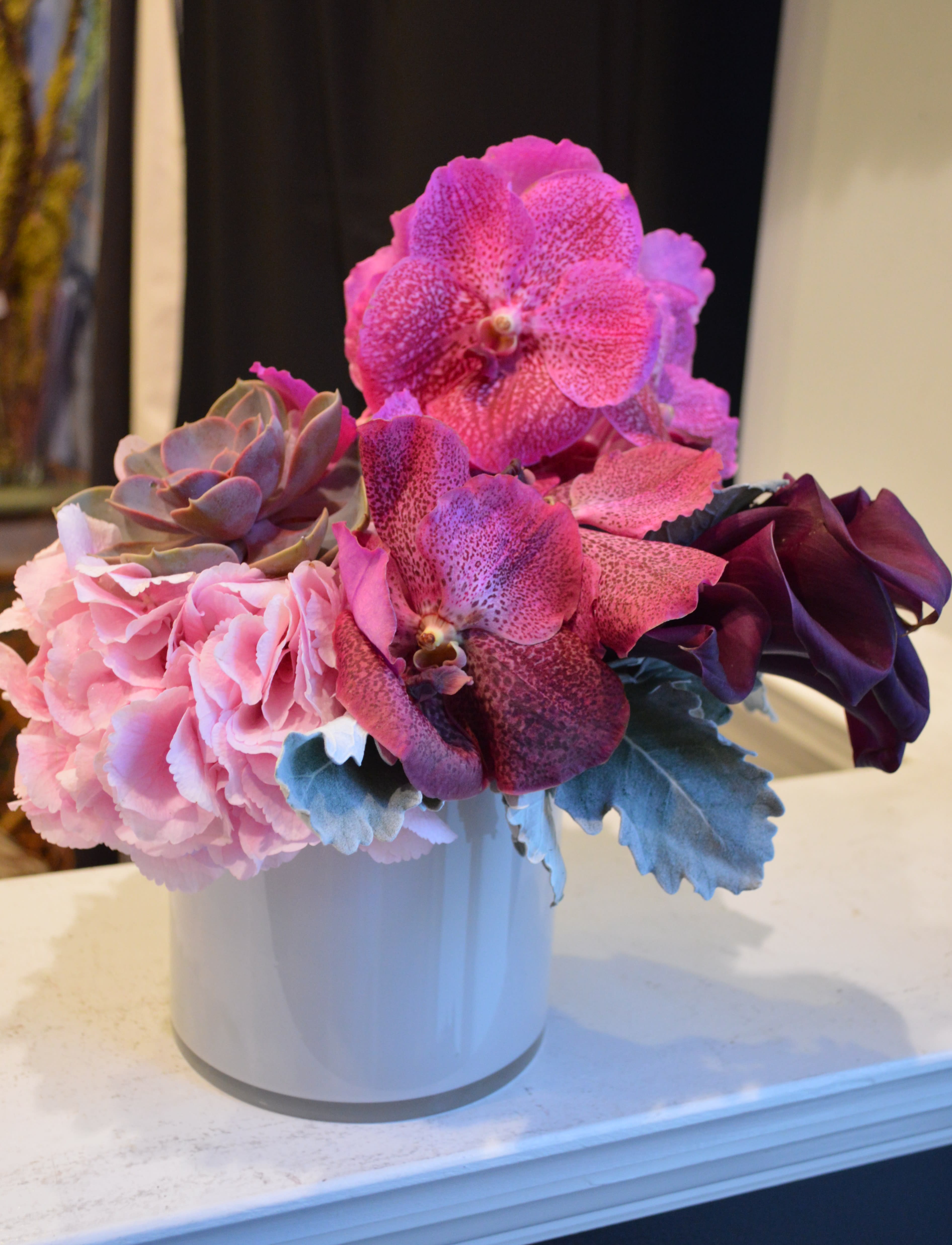Girl Friday - hydrangea, calla lilies, vanda orchids, succulent, &amp; dusty miller in a white glass vase.