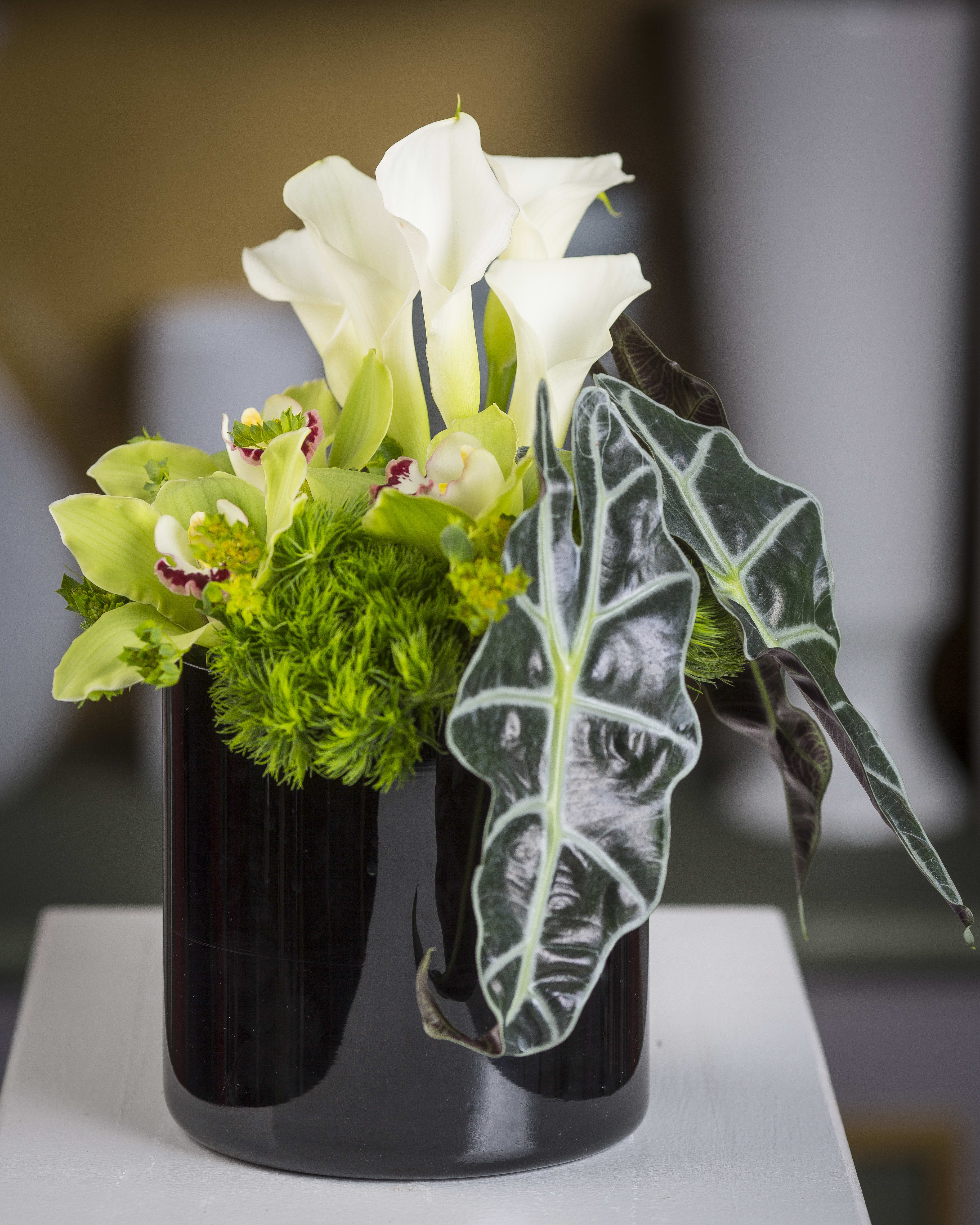 Trick - Calla lilies, trick &amp; cymbidium orchids in a black glass container.