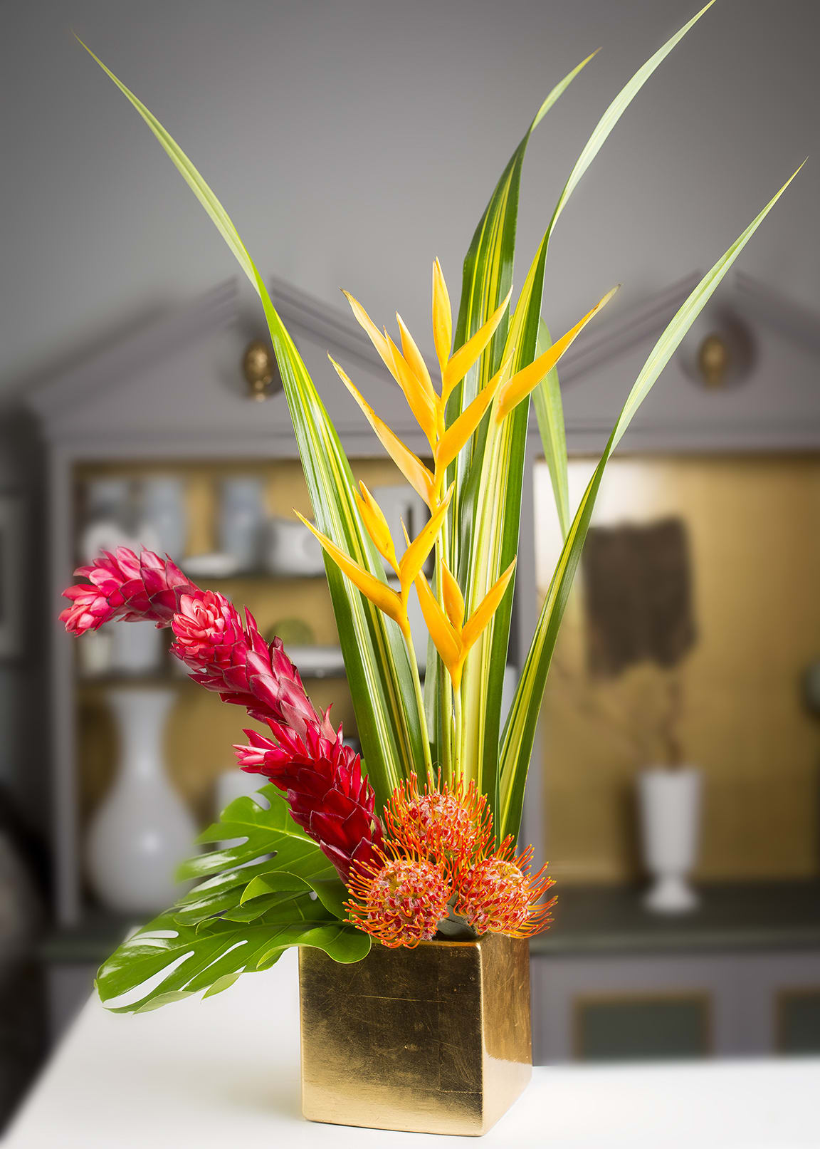 Tropical Cushion - Ginger, parakeets, pins &amp; foliage in a square gold container.