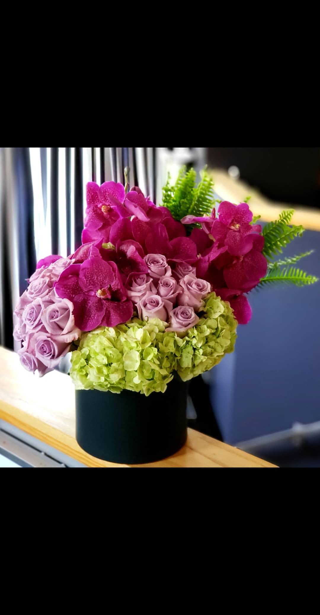 Raspberry Mojito  - Hydrangeas, roses, fern &amp; vanda orchids in a black round container. 