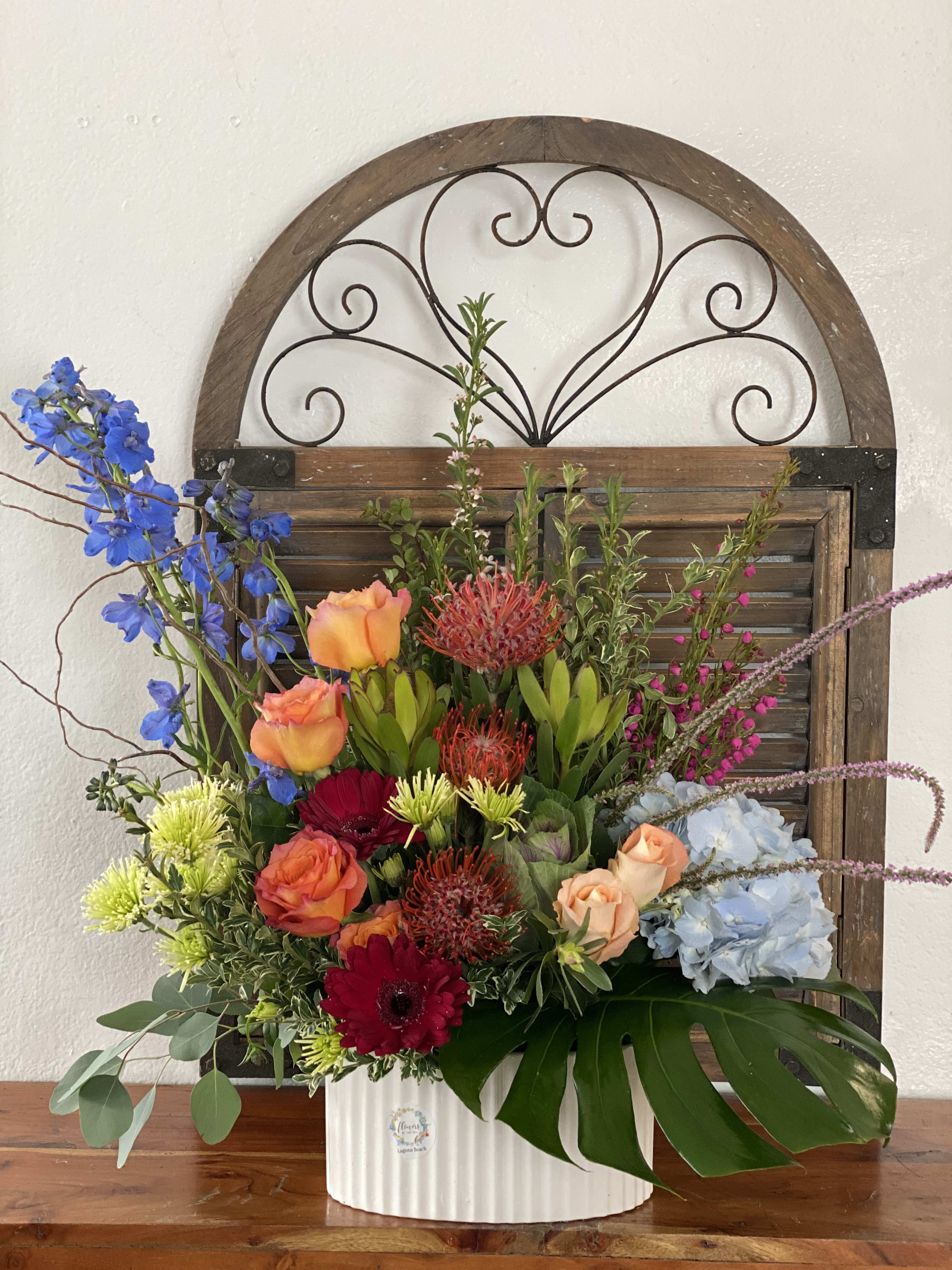 Delphinium Joy - This grand arrangement has a mixed color combination of delphiniums, protea, hydrangeas, roses, and others.